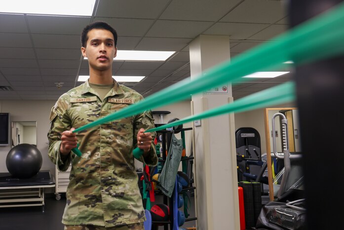 U.S. Air Force Airman 1st Class Nicholas Santos, 375th Medical Group physical therapy technician, Keesler Air Force Base, Mississippi, demonstrates an exercise to a patient at the 9th Medical Group physical therapy clinic, while in the Air Force Manning Assist Program at Beale Air Force Base, California, July 12, 2024.