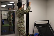 U.S. Air Force Airman 1st Class Nicholas Santos, 375th Medical Group physical therapy technician, Keesler Air Force Base, Mississippi, demonstrates an exercise to a patient at the 9th Medical Group physical therapy clinic, while in the Air Force Manning Assist Program at Beale Air Force Base, California, July 12, 2024.