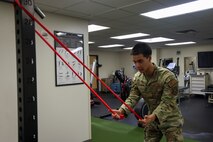U.S. Air Force Airman 1st Class Nicholas Santos, 375th Medical Group physical therapy technician, Keesler Air Force Base, Mississippi, demonstrates an exercise to a patient at the 9th Medical Group physical therapy clinic, while in the Air Force Manning Assist Program at Beale Air Force Base, California, July 12, 2024.