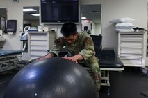U.S. Air Force Airman 1st Class Nicholas Santos, 375th Medical Group physical therapy technician, Keesler Air Force Base, Mississippi, demonstrates an exercise to a patient at the 9th Medical Group physical therapy clinic at Beale Air Force Base, California, July 12, 2024.
