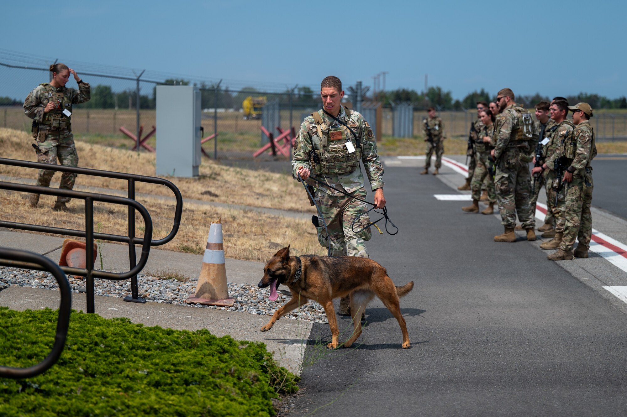 Staff Sgt. Damien Dennis, a military working dog handler assigned to the 92nd Security Forces Squadron, sweeps the outside of the Alert facility with his K-9 partner Ggumula, a MWD, during a no-notice Nuclear Operational Readiness Inspection at Fairchild Air Force Base, Washington, July 16, 2024. Air Mobility Command's Inspector General team conducted the no-notice NORI from July 16 - 18, during which the 92nd Air Refueling Wing and 141st ARW received same-day notification of the evaluation of the base's capability to perform as a nuclear support unit. Various capabilities at Fairchild AFB enable units to generate and provide, when directed, specially trained and equipped KC-135 Stratotanker aircrews to conduct critical air refueling of U.S. Strategic Command-assigned nuclear-capable bombers and Nuclear Command, Control and Communication aircraft. No-notice inspections validate that Airmen are always postured and ready with a credible force to assure, deter and defend in an increasingly complex security environment. No-notice and limited-notice operational readiness assessments and inspections directly support the plans unveiled by senior Department of the Air Force leaders as the force reoptimizes for Great Power Competition. (U.S. Air Force photo by Airman 1st Class Stassney Davis)