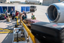 Team Minot Airmen pack luggage onto a passenger jet in preparation for exercise AGILE WARBIRD at Minot Air Force Base, North Dakota, July 13, 2024. AGILE WARBIRD demonstrates Minot's ability to shift operations from centralized physical infrastructures to a network of smaller, dispersed locations that can complicate adversary planning and provide more options for joint force commanders. (U.S. Air Force photo by Senior Airman Alexander Nottingham)
