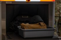 An X-ray security scanner scans luggage at the Minot Air Force Base (AFB) passenger terminal in preparation for exercise AGILE WARBIRD at Minot AFB, North Dakota, June 13, 2024. Exercises like these sharpen Airmen’s ability to mobilize quickly and ensure they are prepared to operate Minot bombers from anywhere at a moment’s notice. (U.S. Air Force photo by Senior Airman Alexander Nottingham)