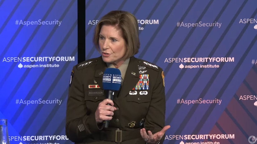 A female Army general speaks into a microphone.