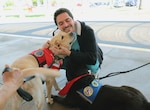 Tripler Army Medical Center- Oscar and Bear, two of Tripler Army Medical Center’s dedicated volunteer therapy dogs, have been serving with the American Red Cross Animal Visitation Program since 2016. Lorna and Al Hu, the primary handlers for the Labrador team, tirelessly provide comfort and emotional support services to military members, veterans, and families at the hospital.