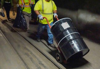 HALAWA, Hawaii (July 8, 2024) A Navy Closure Task Force-Red Hill (NCTF-RH) contractor moves a 55-gallon drum containing sludge from fuel tank 7 at the Red Hill Bulk Fuel Storage Facility (RHBFSF) in Halawa, Hawaii, July 8, 2024. About 12 gallons of sludge were removed from the tank. Sludge removal is part of the tank cleaning process for decommissioning the tanks. Charged with the safe decommissioning of the RHBFSF, NCTF-RH was established by the Department of the Navy as a commitment to the community and the environment. (U.S. Navy photo by Mass Communication Specialist 1st Class Glenn Slaughter)