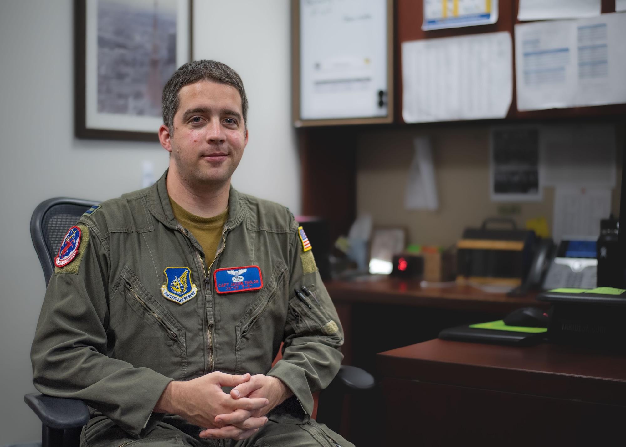 U.S. Air Force Capt. Jacob Taylor, an instructor pilot and the 459th Airlift Squadron executive officer, sits in a chair in front of his desk.