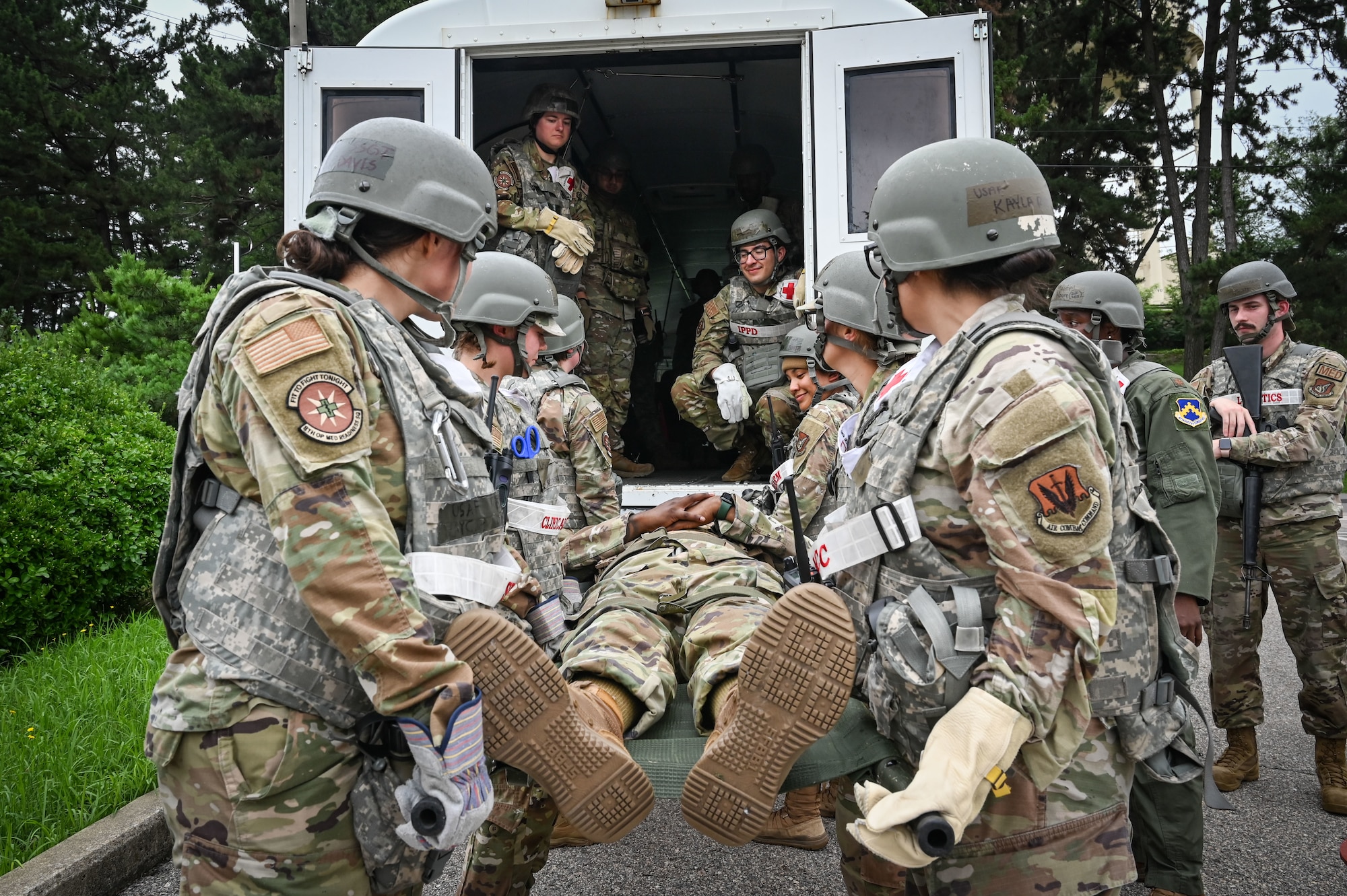 Airmen assigned to the 8th Medical Group transport a simulated patient into an ambulance bus during exercise Beverly Sentinel 24-2.