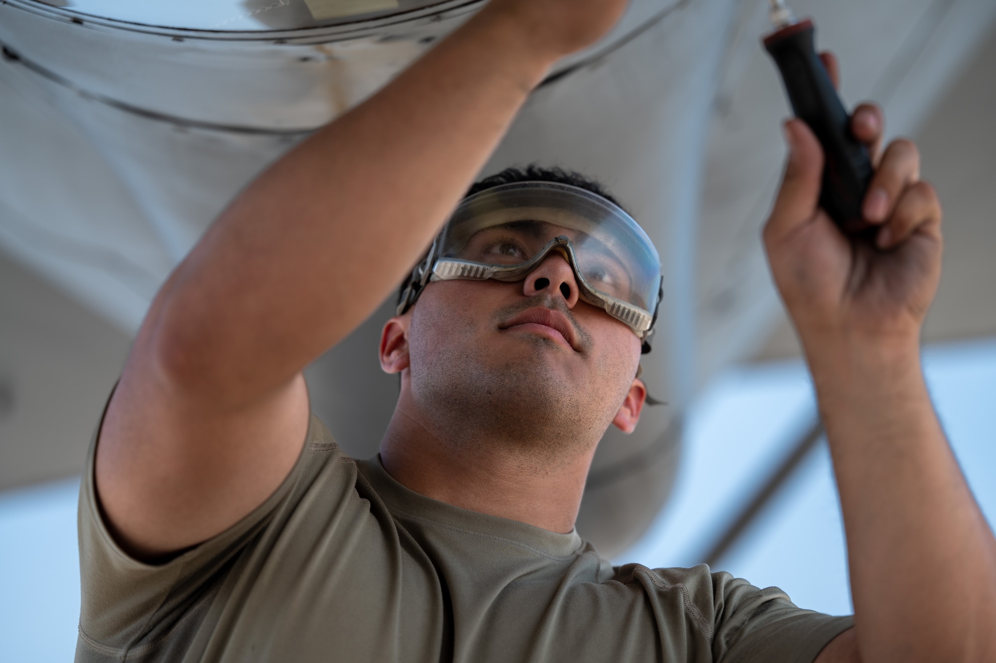 Senior Airman Augustin Rios, a crew chief assigned to the 92nd Aircraft Maintenance Squadron, removes a KC-135 Stratotanker boom sighting window for cleaning during a no-notice Nuclear Operational Readiness Inspection at Fairchild Air Force Base, Washington, July 16, 2024. Air Mobility Command's Inspector General team conducted the no-notice NORI from July 16 - 18, during which the 92nd Air Refueling Wing and 141st ARW received same-day notification of the evaluation of the base's capability to perform as a nuclear support unit. Various capabilities at Fairchild AFB enable units to generate and provide, when directed, specially trained and equipped KC-135 Stratotanker aircrews to conduct critical air refueling of U.S. Strategic Command-assigned nuclear-capable bombers and Nuclear Command, Control and Communication aircraft. No-notice inspections validate that Airmen are always postured and ready with a credible force to assure, deter and defend in an increasingly complex security environment. No-notice and limited-notice operational readiness assessments and inspections directly support the plans unveiled by senior Department of the Air Force leaders as the force reoptimizes for Great Power Competition. (U.S. Air Force photo by Airman 1st Class Stassney Davis)
