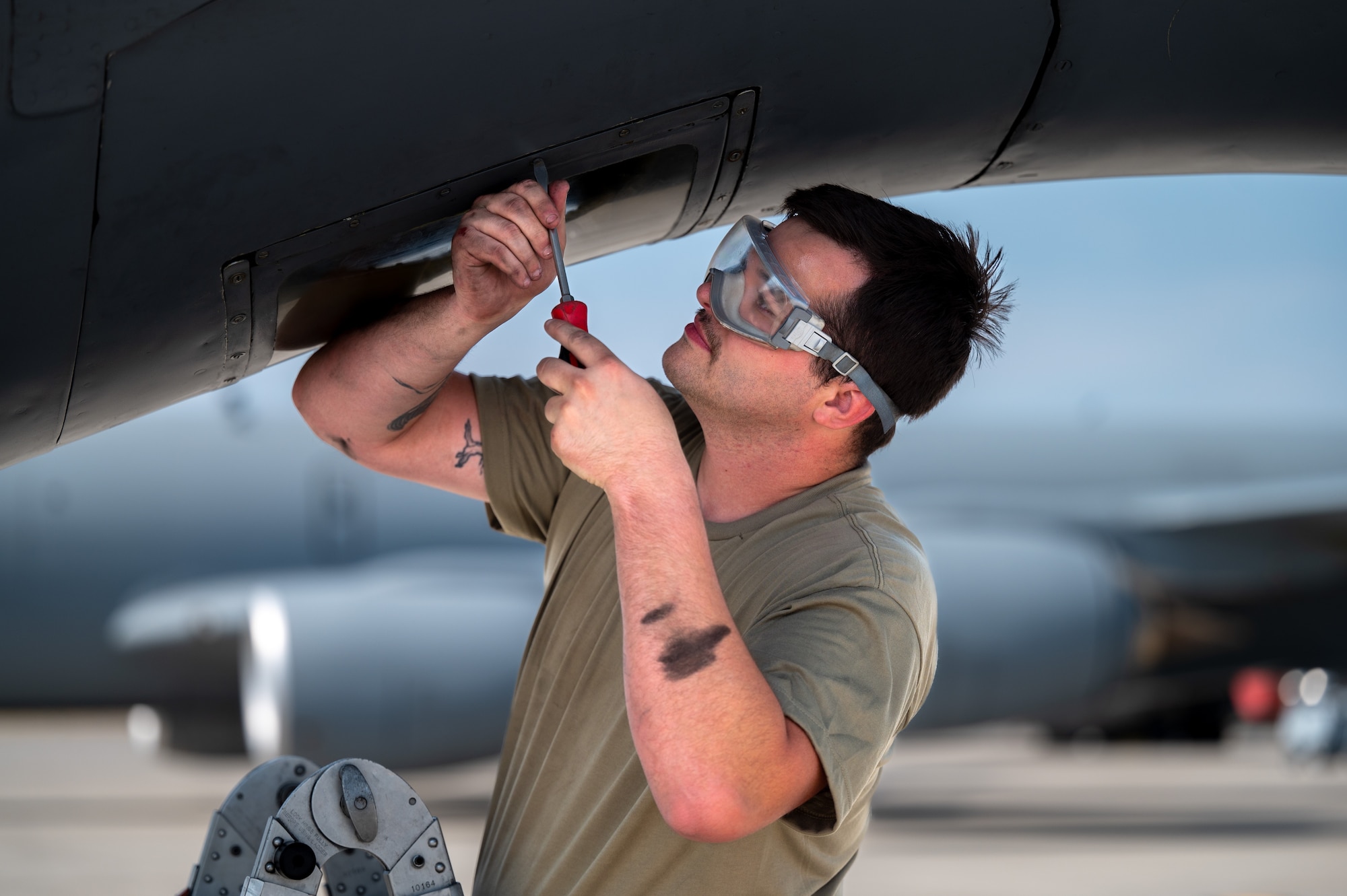 Senior Airman Ryan Folger, a crew chief assigned to the 92nd Aircraft Maintenance Squadron, removes a KC-135 Stratotanker boom sighting window for cleaning during a no-notice Nuclear Operational Readiness Inspection at Fairchild Air Force Base, Washington, July 16, 2024. Air Mobility Command's Inspector General team conducted the no-notice NORI from July 16 - 18, during which the 92nd Air Refueling Wing and 141st ARW received same-day notification of the evaluation of the base's capability to perform as a nuclear support unit. Various capabilities at Fairchild AFB enable units to generate and provide, when directed, specially trained and equipped KC-135 Stratotanker aircrews to conduct critical air refueling of U.S. Strategic Command-assigned nuclear-capable bombers and Nuclear Command, Control and Communication aircraft. No-notice inspections validate that Airmen are always postured and ready with a credible force to assure, deter and defend in an increasingly complex security environment. No-notice and limited-notice operational readiness assessments and inspections directly support the plans unveiled by senior Department of the Air Force leaders as the force reoptimizes for Great Power Competition. (U.S. Air Force photo by Airman 1st Class Stassney Davis)