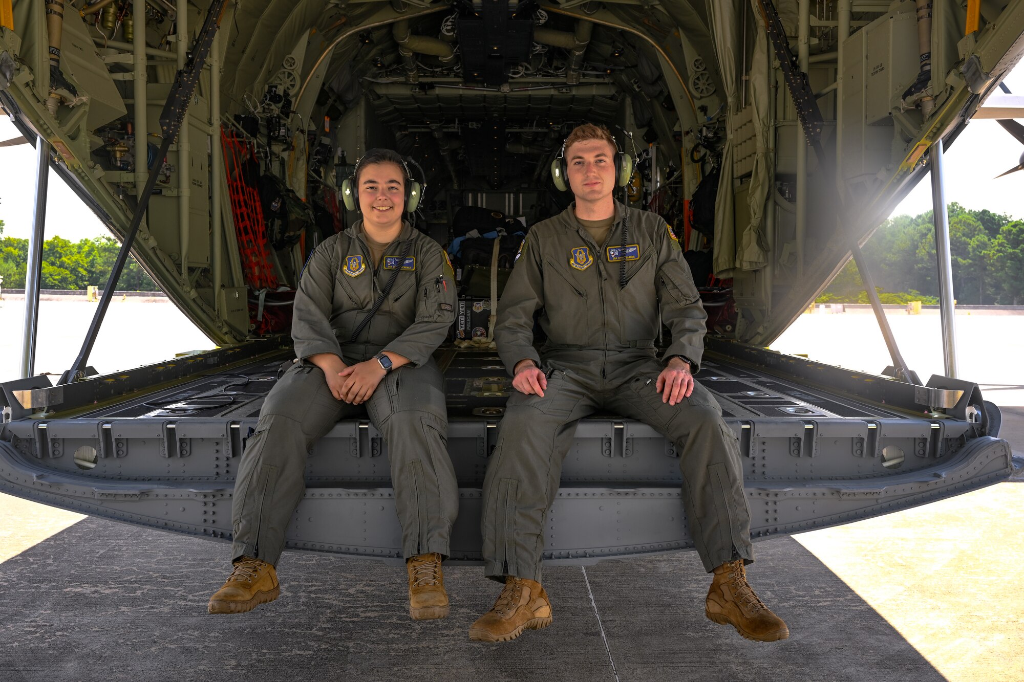Senior Airmen Chloe Lenkner and Christopher Barber, 757th Airlift Squadron loadmasters, pose for a photo on the C-130J-30 Super Hercules at the Lockheed Martin production facility, Marietta, Georgia, July 16, 2024.