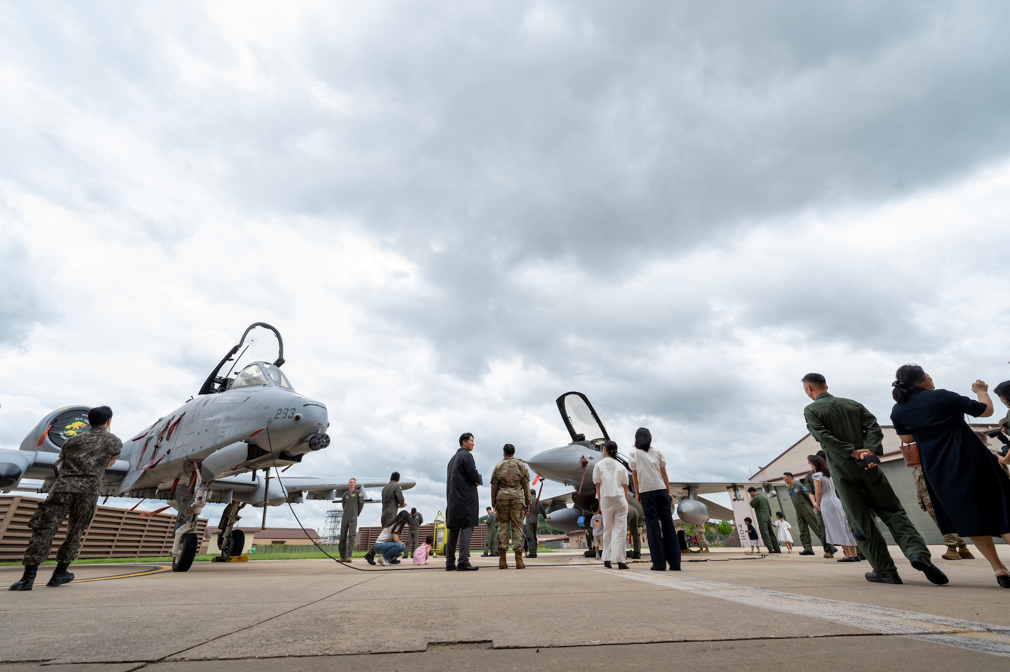 U.S. Air Force Airmen assigned to the 51st Fighter Wing and Republic of Korea Air Force service members and families view an A-10 Thunderbolt II and an F-16 Fighting Falcon during Pilot’s Day at Osan Air Base, Republic of Korea, July 17, 2024. Pilot’s Day was a special event hosted for the first time by the 51st Fighter Wing and ROK Air Force Operations Command allowing ROKAF families to learn about the collaboration of both enterprises and occupations. (U.S. Air Force photo by Senior Airman Sabrina Fuller-Judd)