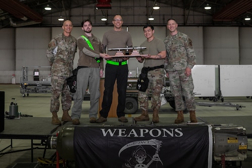493rd Fighter Generation Squadron weapons load crew stand together with an award upon winning the 48th Maintenance Group 2nd Quarter Load Crew Competition