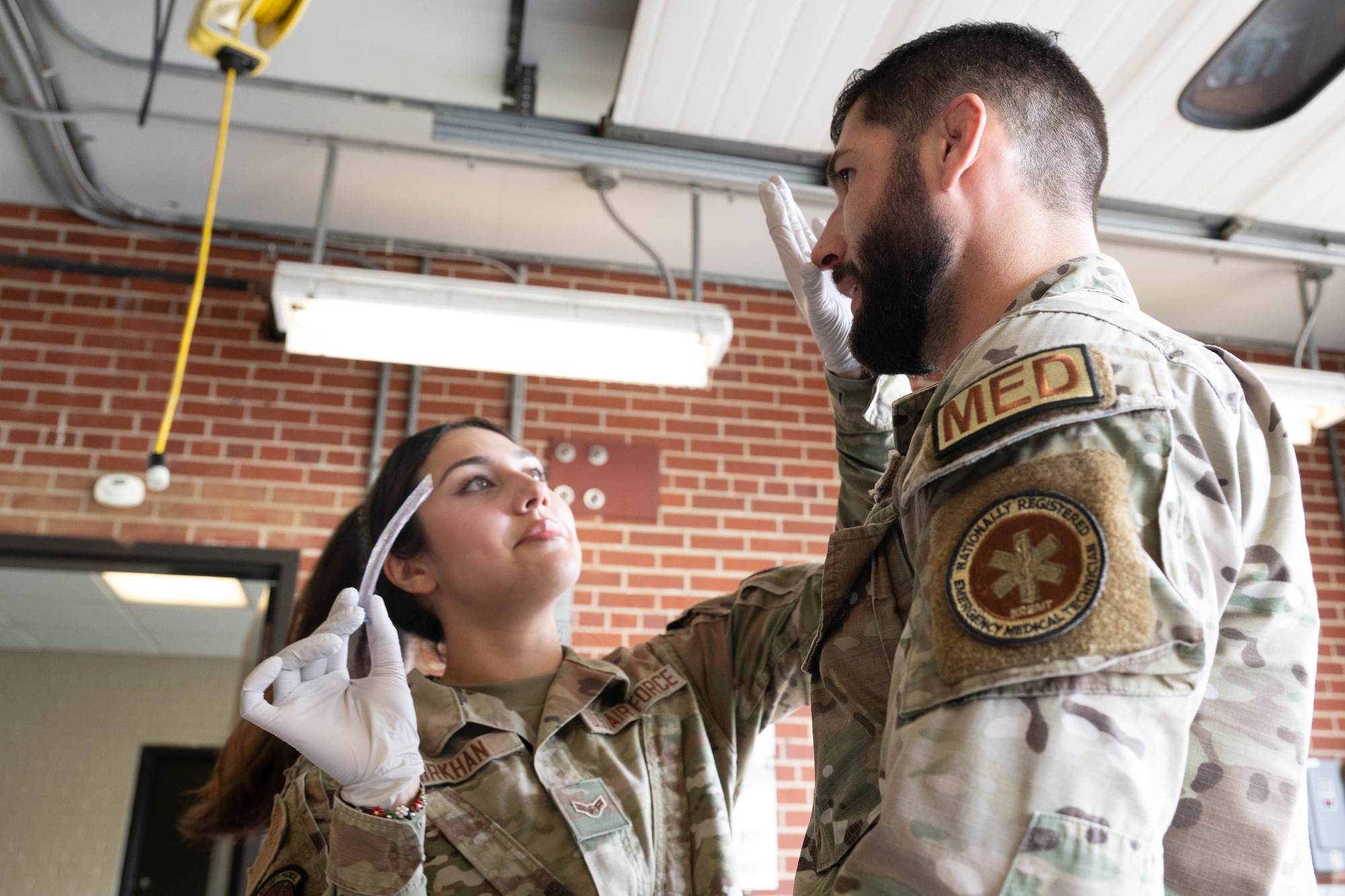 U.S. Air Force Airman 1st Class Maria Mirkhan and Staff Sgt. Max Robichaud, both 436th Health Care Operations Squadron ambulance services technicians, demonstrate a nasopharyngeal airway to a group of honorary commanders during a tour of the medical clinic at Dover Air Force Base, Delaware, July 18, 2024. The HCCs toured various elements of the 436th MDG to familiarize them with the group's facilities, mission and capabilities. (U.S. Air Force photo by Mauricio Campino)