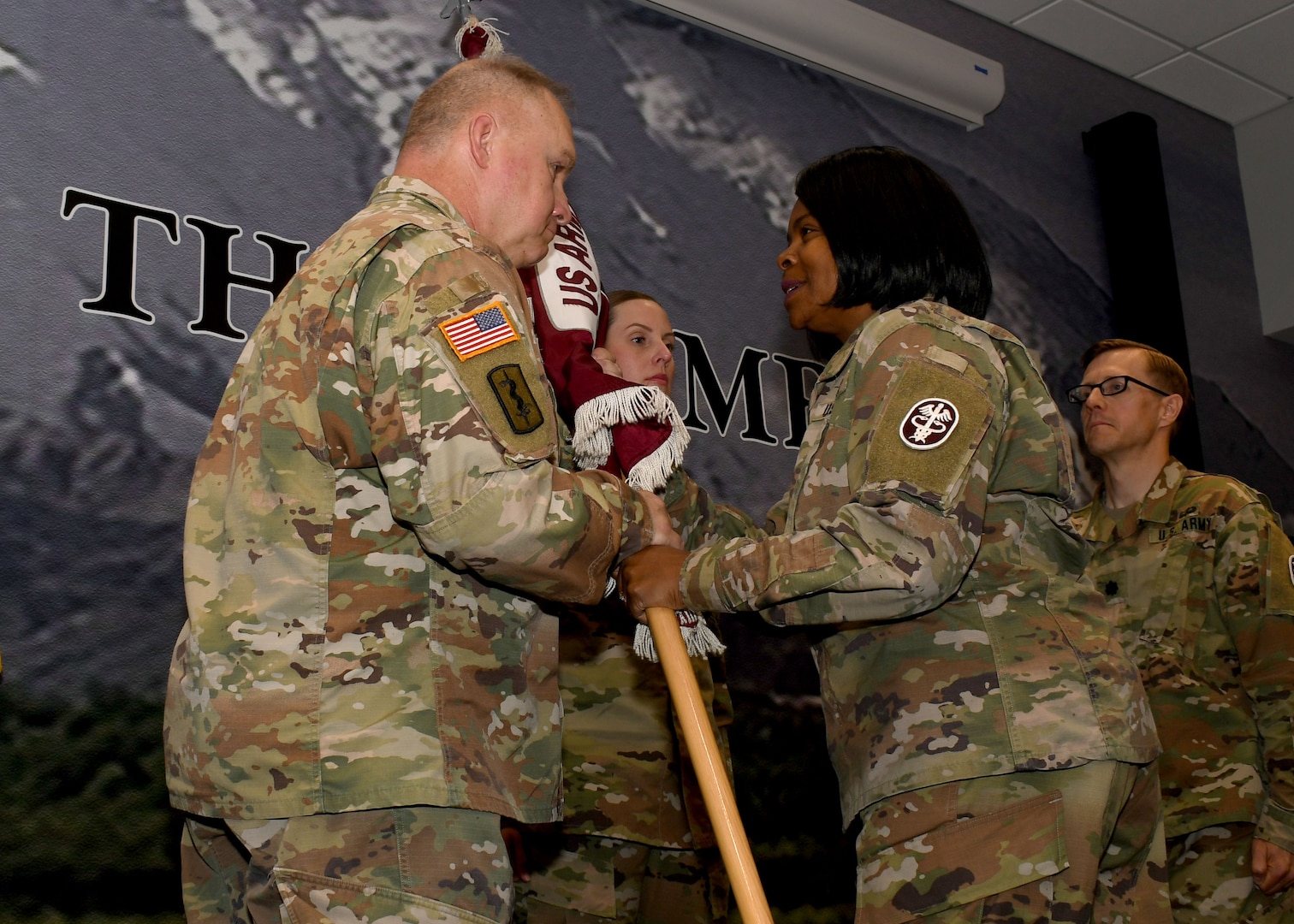 Photo of Col. Tawanna M. McGhee-Thondique, commander of the Dental Health Command-East, passing the colors of the Fort Drum Dental Health Activity to Col. Ralf C. Beilhardt, the incoming commander of the DENTAC, during a change of command ceremony.