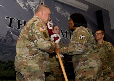 Photo of Col. Tawanna M. McGhee-Thondique, commander of the Dental Health Command-East, passing the colors of the Fort Drum Dental Health Activity to Col. Ralf C. Beilhardt, the incoming commander of the DENTAC, during a change of command ceremony.