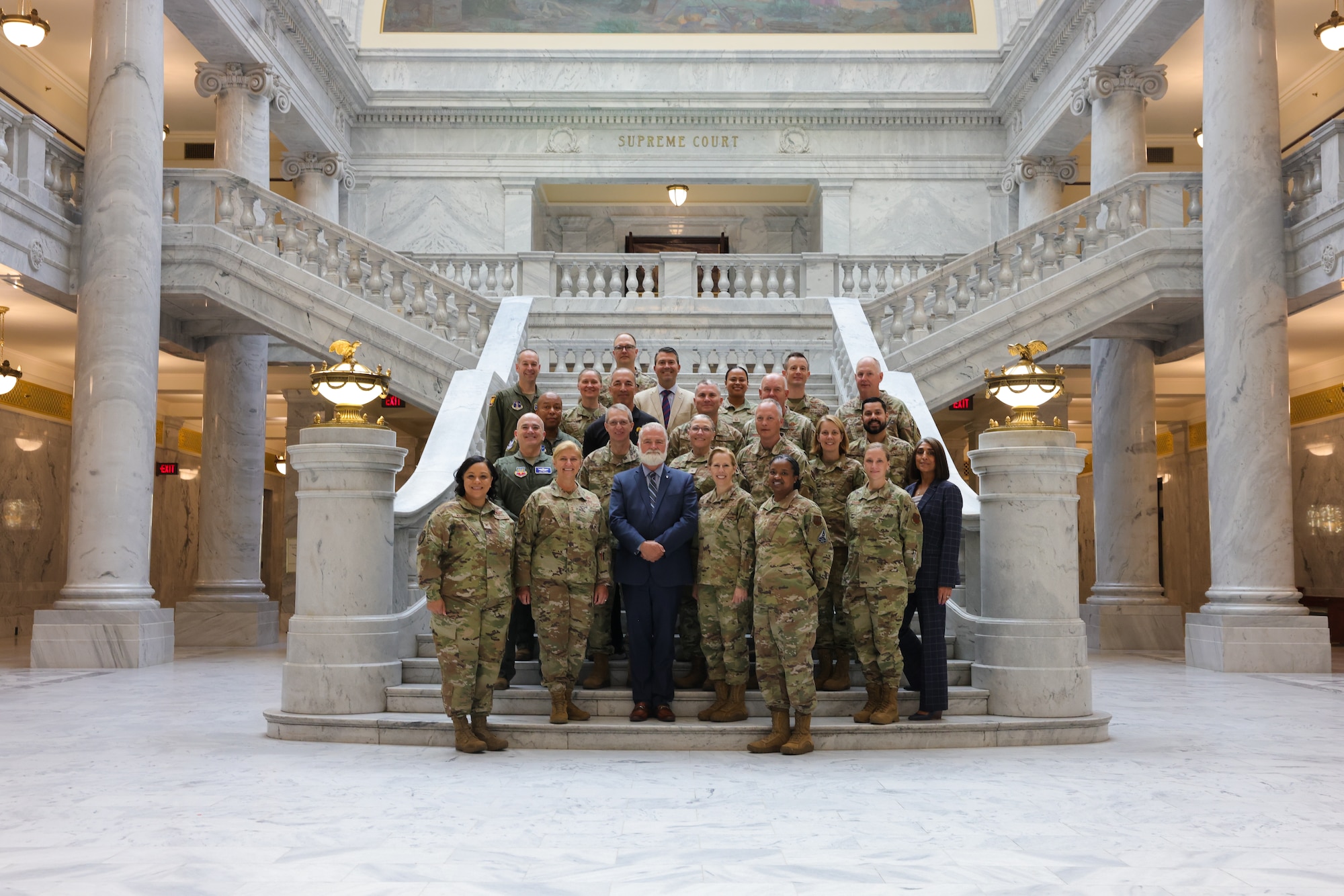 A group of people in uniform pose for a photo inside the Utah State Capitol building.
