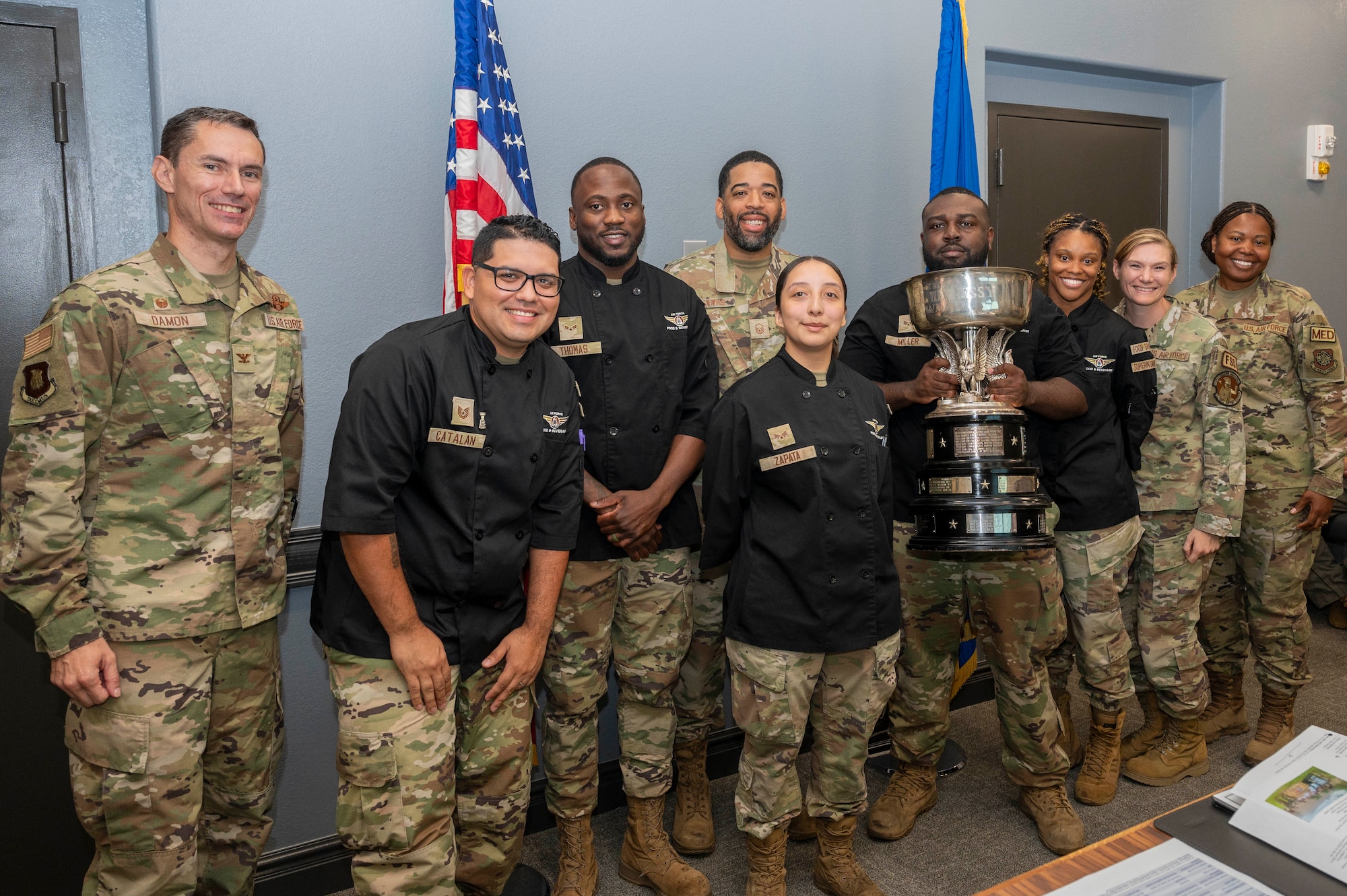 The Chisholm Trail Inn Dining Facility team poses for a photo while holding the 68th annual Air Force John L. Hennessy Award. The team took home the award after beating 70 facilities across the Air Force.