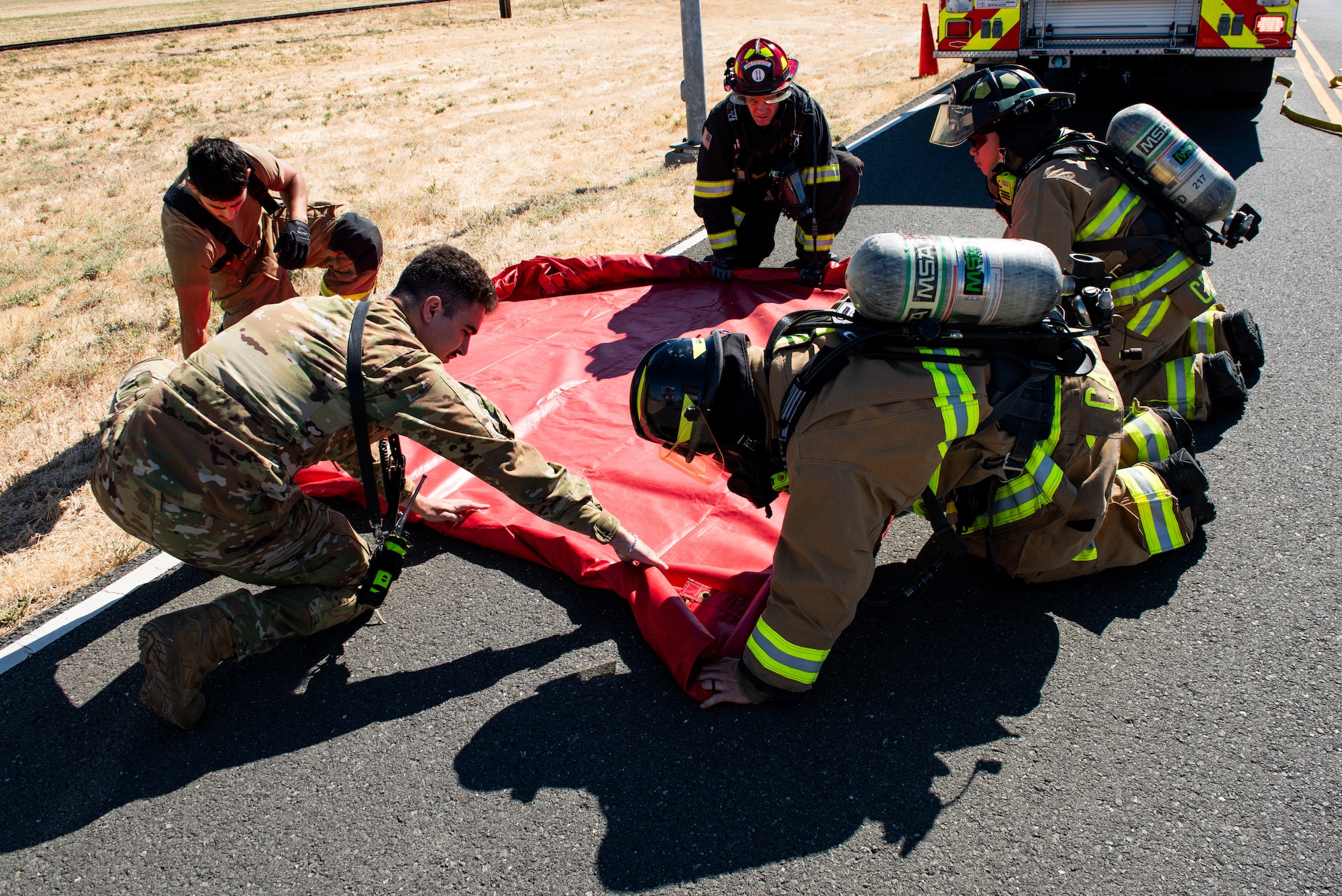 Firefighters lay out decontamination tarp.