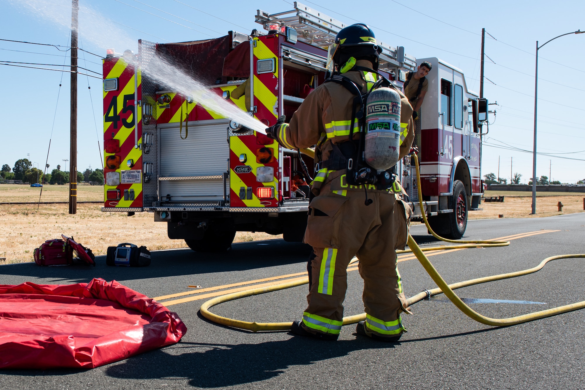 Firefighter discharging a fire hose.