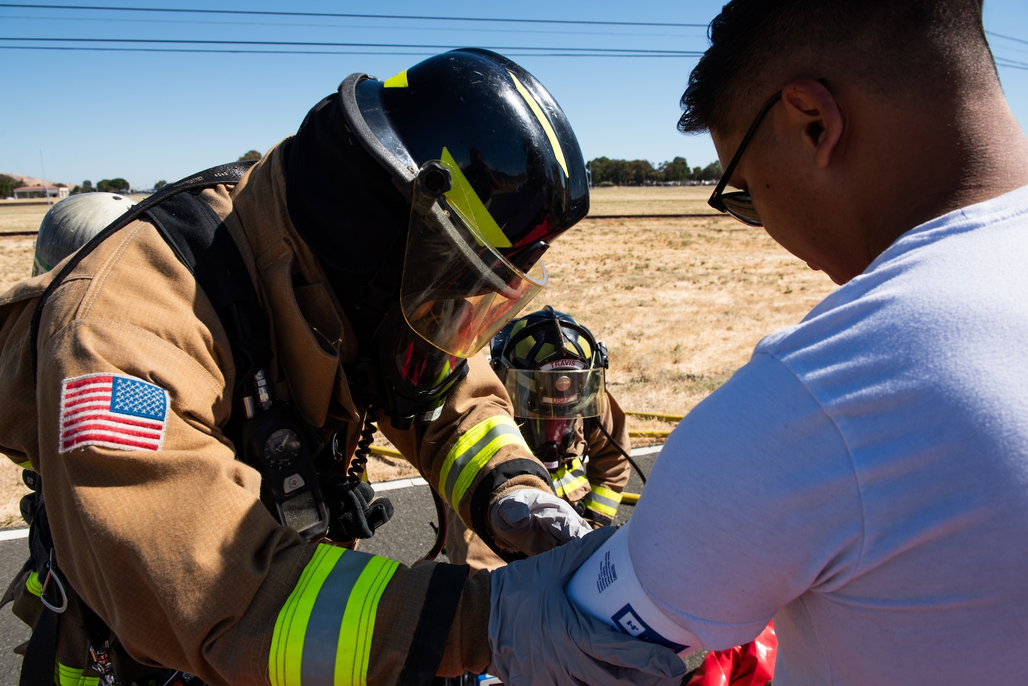 Firefighters take vitals of simulated patient.