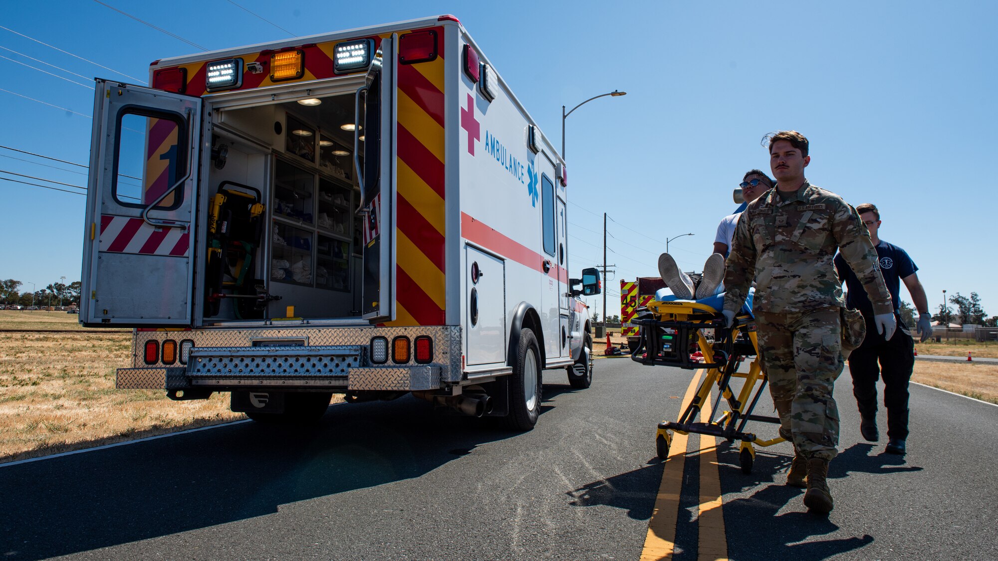 Paramedic and EMT moving a simulated patient into an ambulance