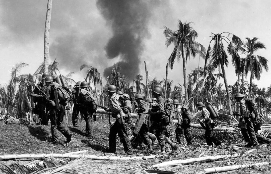 Troops of 12th Cavalry move from beach, past splintered trees and fires caused by heavy bombardment preceding their landing on Leyte Island,
Philippine Islands