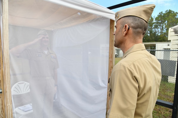 Cmdr. Michael Kavanaugh relieving Cmdr. Ian Sutherland of command of the Navy Entomology Center of Excellence at the Navy Entomology Center of Excellence’s Change of Charge Ceremony on June 21st, 2024, in Jacksonville, Florida. To commemorate the U.S. Navy’s 248th year of existence, Sutherland had 248 Aedes Aegypti mosquitoes released inside of a seven-foot cube to join him during his speech. To NECE’s knowledge, this is the first-time mosquitoes have been utilized in a change of charge ceremony. (Courtesy photo by Mass Communicator Specialist 2nd Class Matthew Riggs)