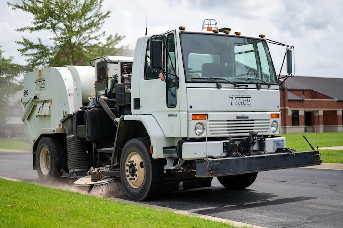 Airman drives a sweeper truck to clean the roads