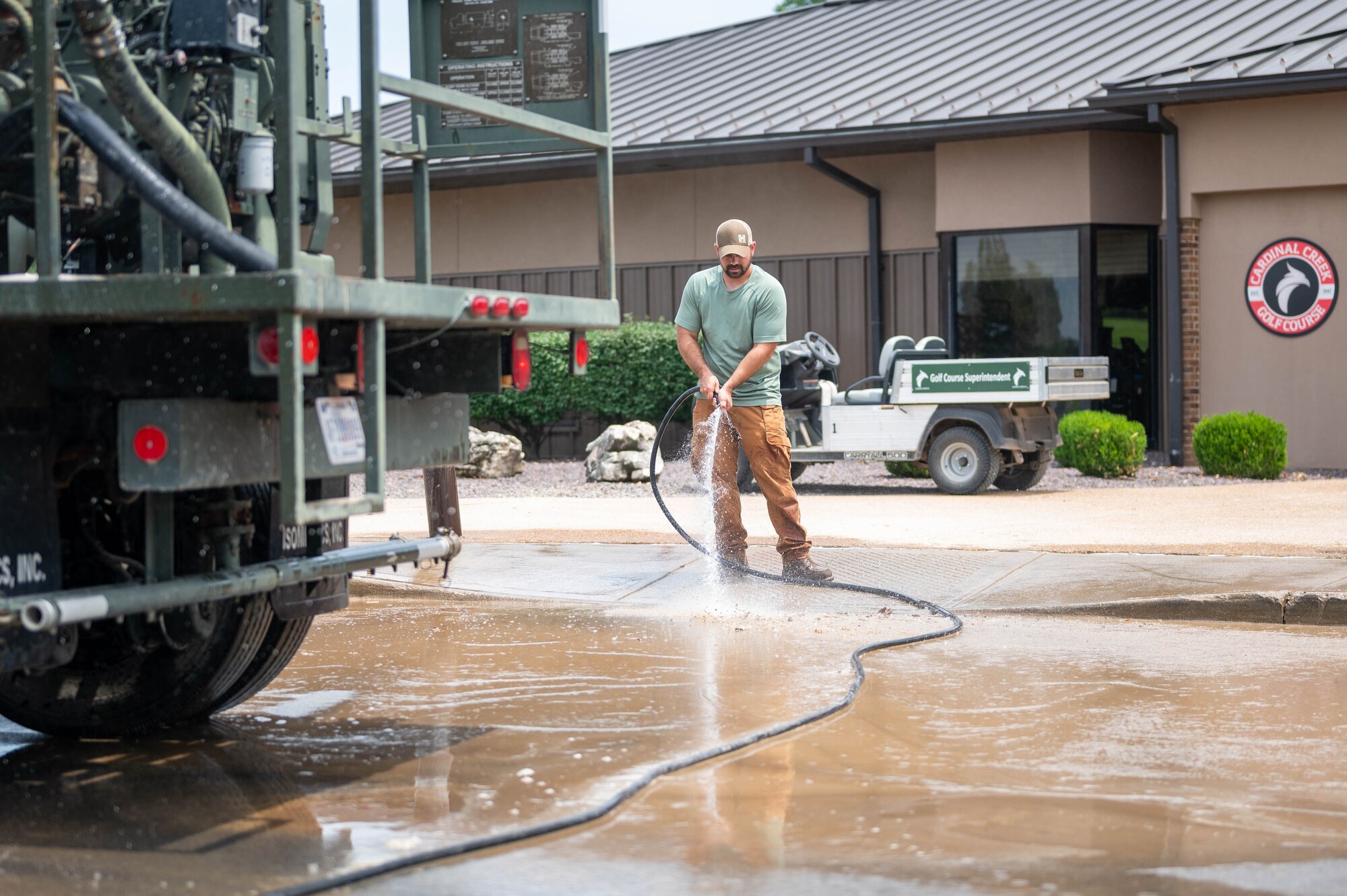 man sprays off sidewalk