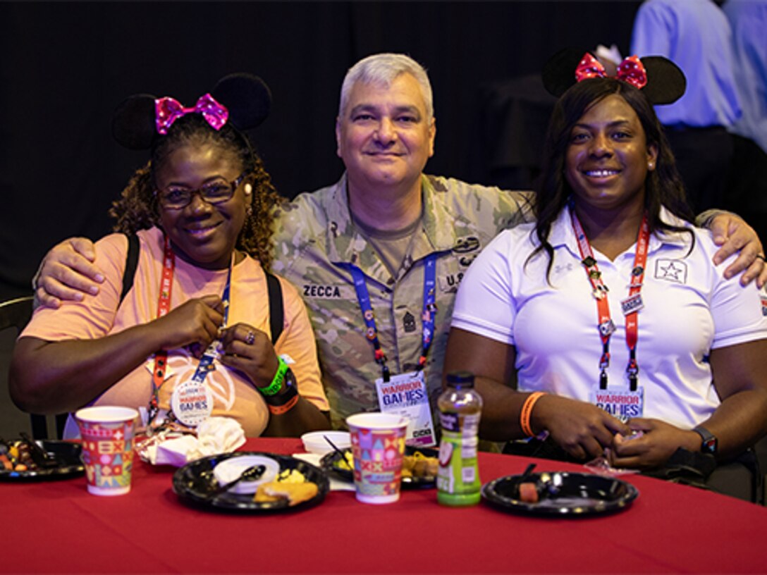 U.S. Army veteran Corine Hamilton poses with her mother, Nadine Hamilton, and U.S. Army Command Sgt. Maj. Joel Zecca at the character breakfast during the 2024 Department of Defense Warrior Games