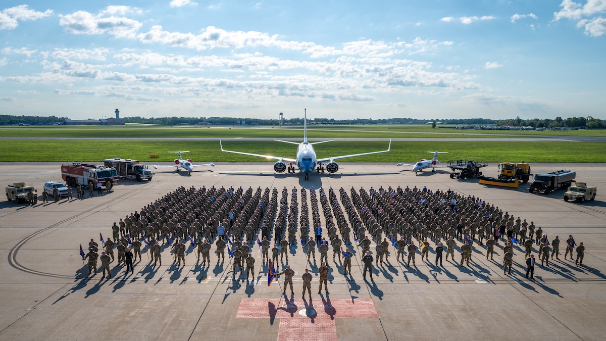 Military members pose for a group photo on the flightline of Scott Air Force base.