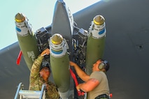 U.S. Air Force Airman Moises Martinez (left) and Staff Sgt. Dylan Lindgren, 69th Bomb Squadron load crew members, attach guided munitions to a B-52H Stratofortress during the 5th Maintenance Group’s inaugural Mission Generation Competition at Minot Air Force Base, North Dakota, July 17, 2024. The Airmen competed to determine which team could safely accomplish assigned tasks in the shortest amount of time.