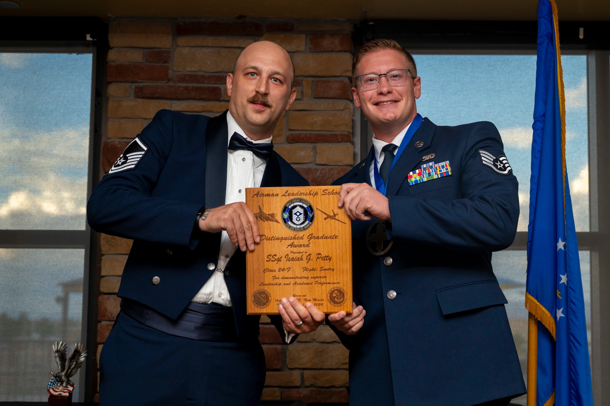 U.S. Air Force Staff Sgt. Isaiah Petty, Airman Leadership School Graduate, right, accepts the Distinguished Graduate Award from Holloman Top III representative U.S. Air Force Master Sgt. Bryan Spangler, during the graduation of Joel C. Mayo ALS Class 24-F at Holloman Air Force Base, New Mexico, July 18, 2024.
