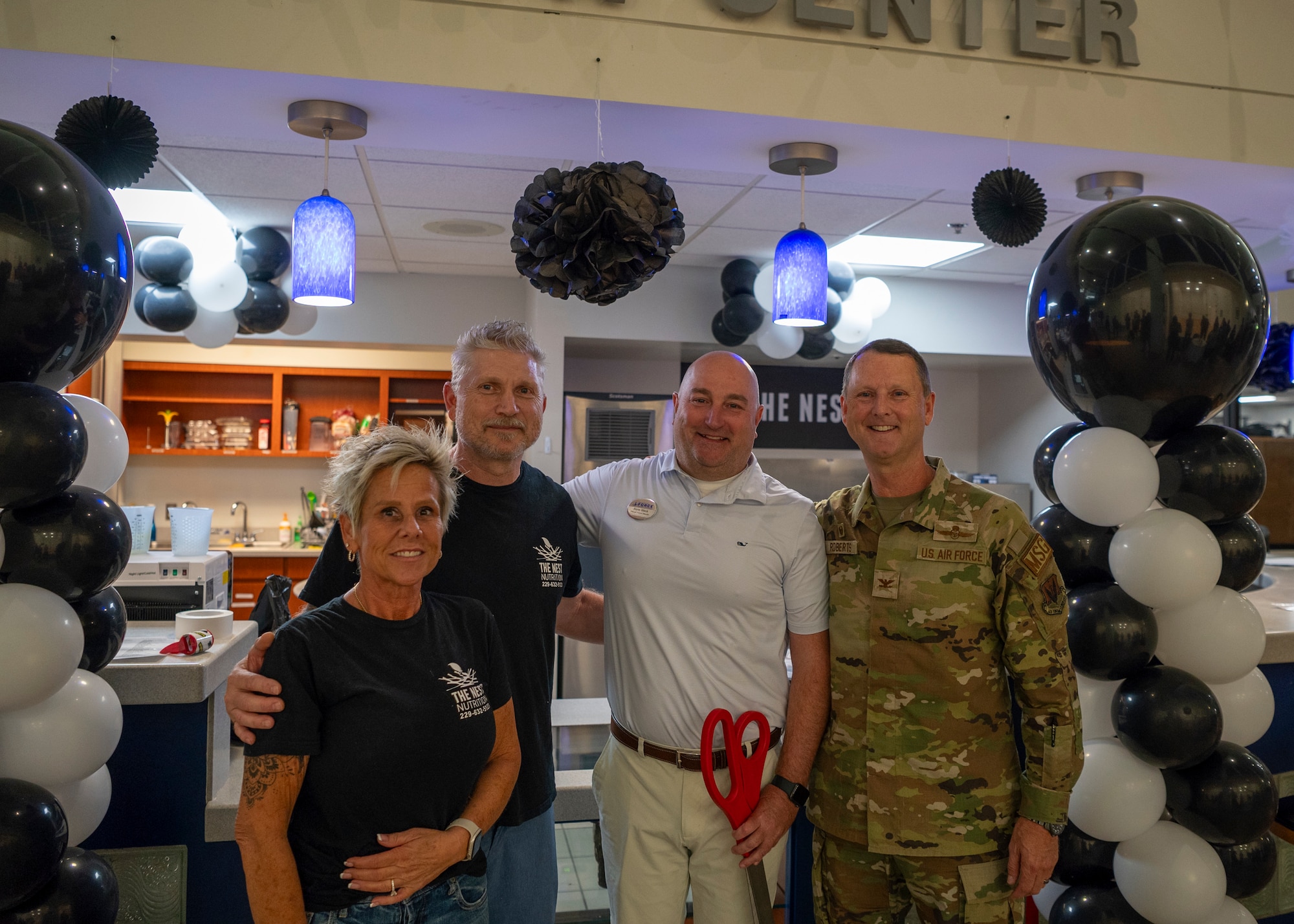 U.S. Air Force Col. Ken Roberts (right), 23rd Mission Support Group commander, and Steve Black, 23rd Force Support Squadron fitness center director (second from right) pose with Chris and Kim Johnson, Nest Nutrition owners, during a ribbon cutting ceremony at Moody Air Force Base, Georgia, July 16, 2024. Eating healthy, balanced meals, along with getting adequate sleep are key to improving physical stamina, injury reduction and overall good health – adding to the overall mission capabilities of Airmen across the USAF.  (U.S. Air Force photo by Airman 1st Class Leonid Soubbotine)