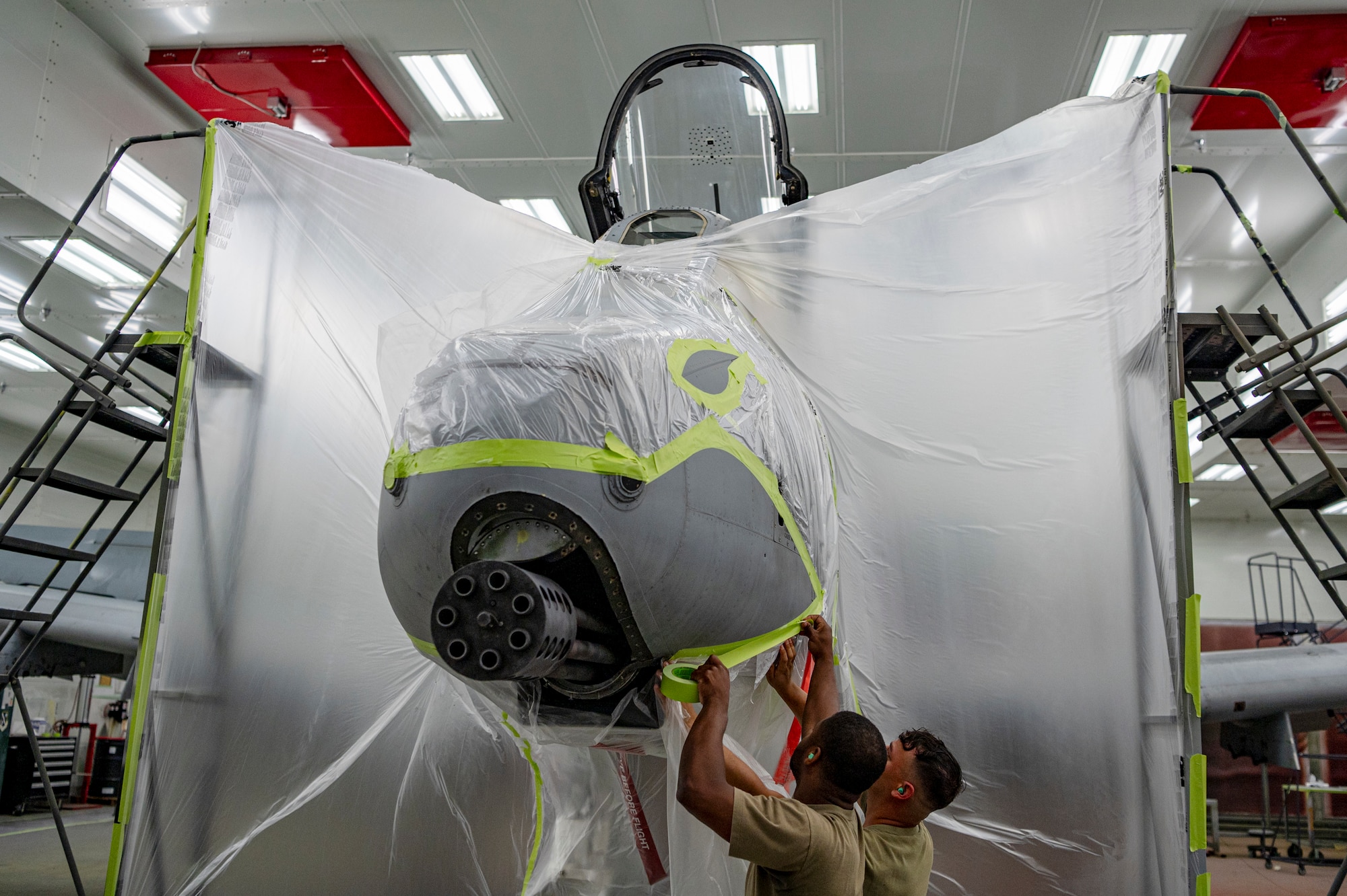 U.S. Staff Sgt. William Rogers, 23rd Maintenance Squadron aircraft structural maintenance craftsman, left, and U.S. Air Force Senior Airman Joshua Strickland, 23rd Maintenance Squadron aircraft structural maintenance journeyman, right, prepare an A-10C Thunderbolt II for re-painting at Moody Air Force Base, Georgia, July 16, 2024. During the re-painting process Airmen from the 23rd Maintenance Squadron mask parts of the plane to avoid overspray during the process. (U.S. Air Force photo by Airman 1st Class Leonid Soubbotine)