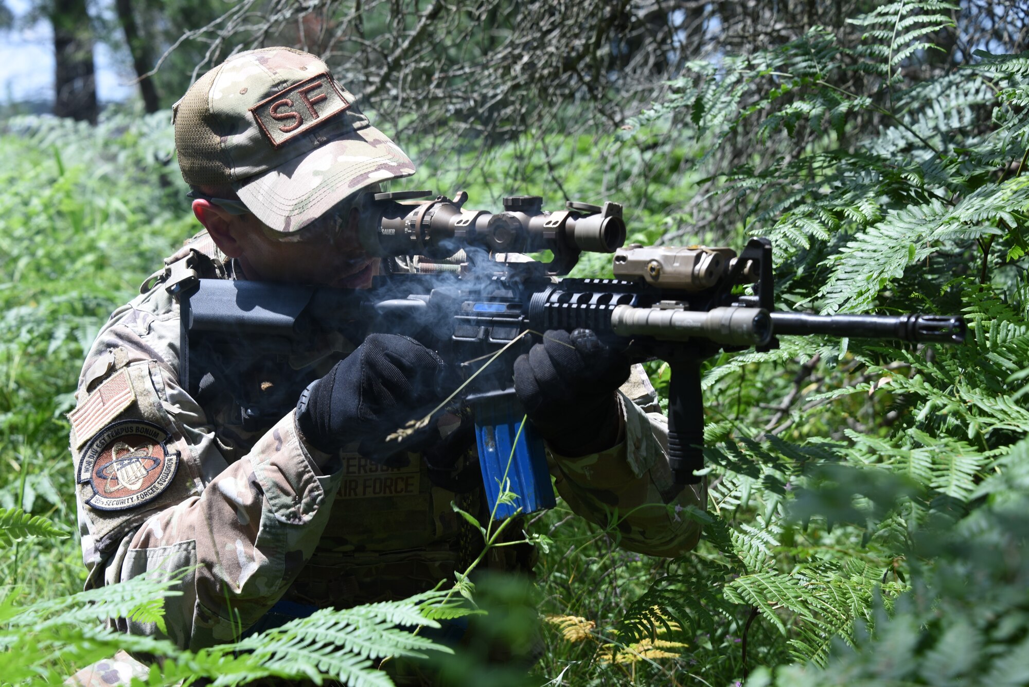 Senior Airman Tyler Peterson, 185th Air Refueling Wing Security Forces, aims an M4A1 rifle while crouching