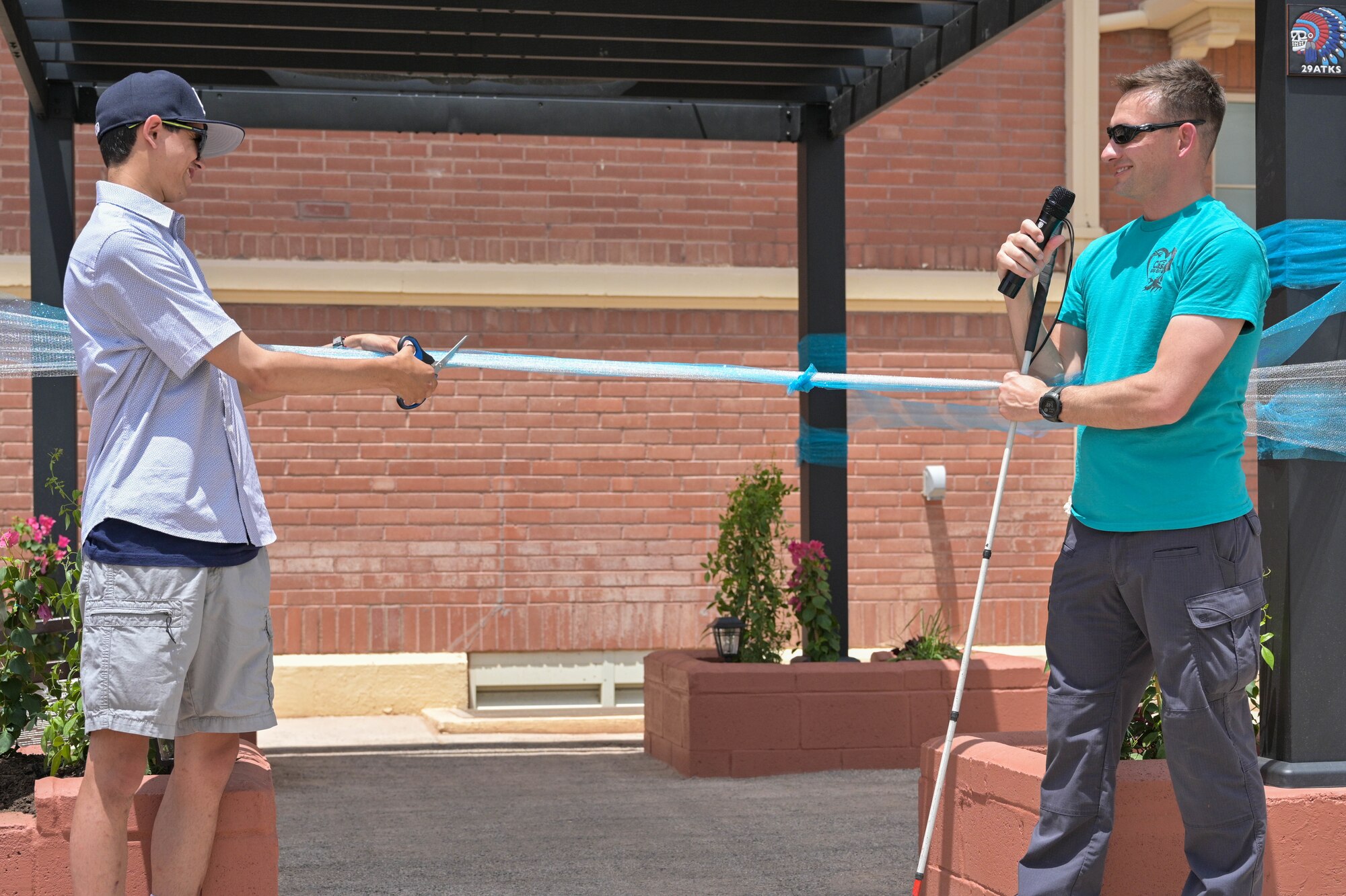 Angel Sanchez, left, and Lt. Col. Brandon Taylor, 29th Attack Squadron commander, cut the ribbon to open a multi-sensory garden at the New Mexico School for the Blind and Visually Impaired in Alamogordo, New Mexico, July 18, 2024.