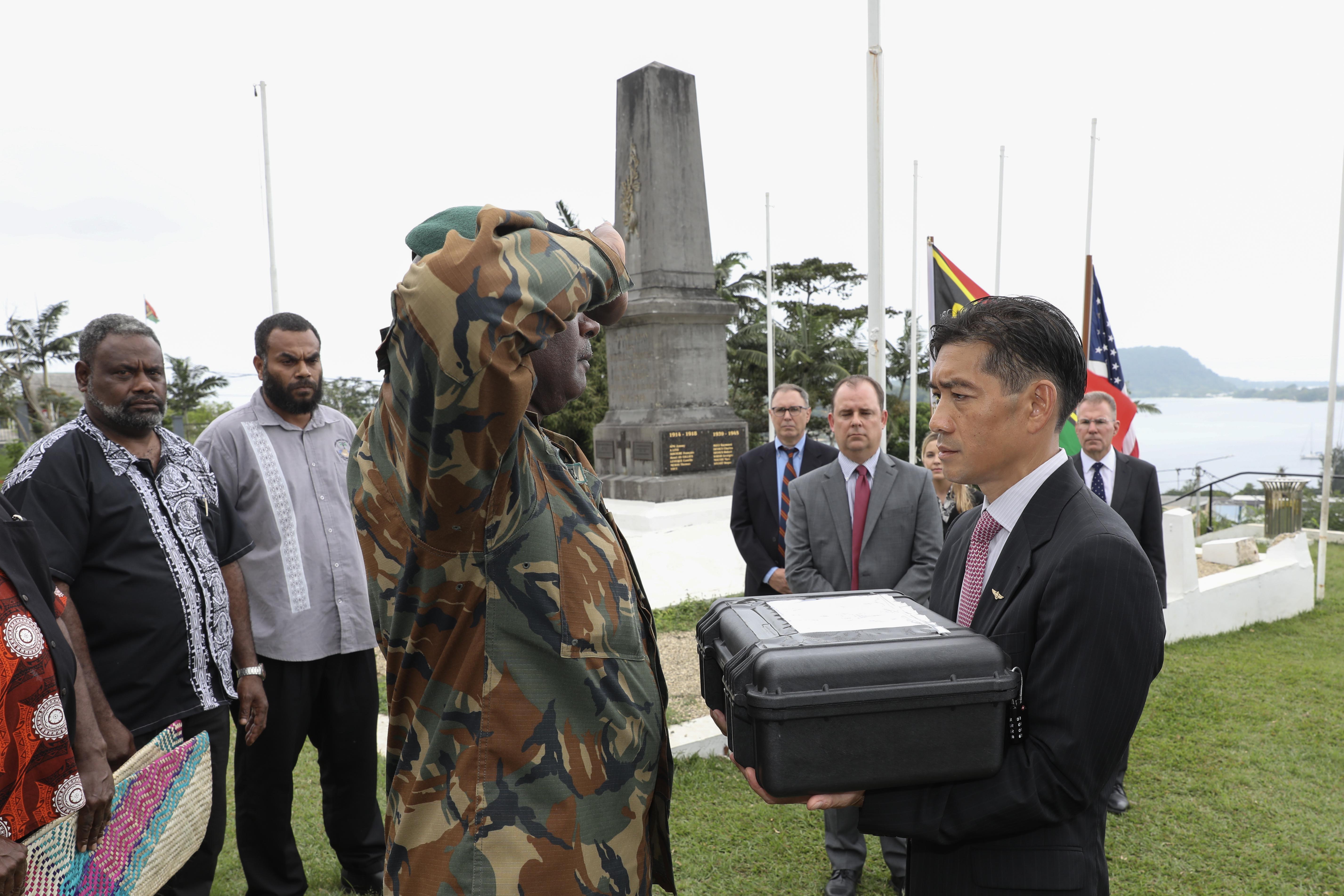 PORT VILA, Vanuatu (July 17, 2024) Col. Astrophile Mwele, commander of the Vanuatu Mobile Force, renders a salute after presenting possible human remains evidence to U.S. Navy Capt. Mark Asuncion, right, the Senior U.S. Official in Vanuatu, during a ceremonial exchange attended by representatives from the Australian High Commission in Vanuatu, the Defense POW/MIA Accounting Agency, Chairman of the Vanuatu National Cultural Council, USAID, and servicemembers assigned to Pacific Partnership 24-2 at the Efate Port Vila War Memorial in Port Vila, Vanuatu. July 17, 2024. The possible human remains evidence were recovered from a U.S. Navy PBY-5 Catalina that crashed in what is now the Republic of Vanuatu during World War II. The DPAA mission is to search for, find and account for missing Defense Department personnel from World War II, the Korean War, the Vietnam War, the Cold War, the Gulf War and other recent conflicts. More than 82,000 Americans remain missing from those conflicts, with 34,000 believed to be recoverable, according to DPAA. (U.S. Navy Photo by Mass Communication Specialist 1st Class Ryan D. McLearnon.)