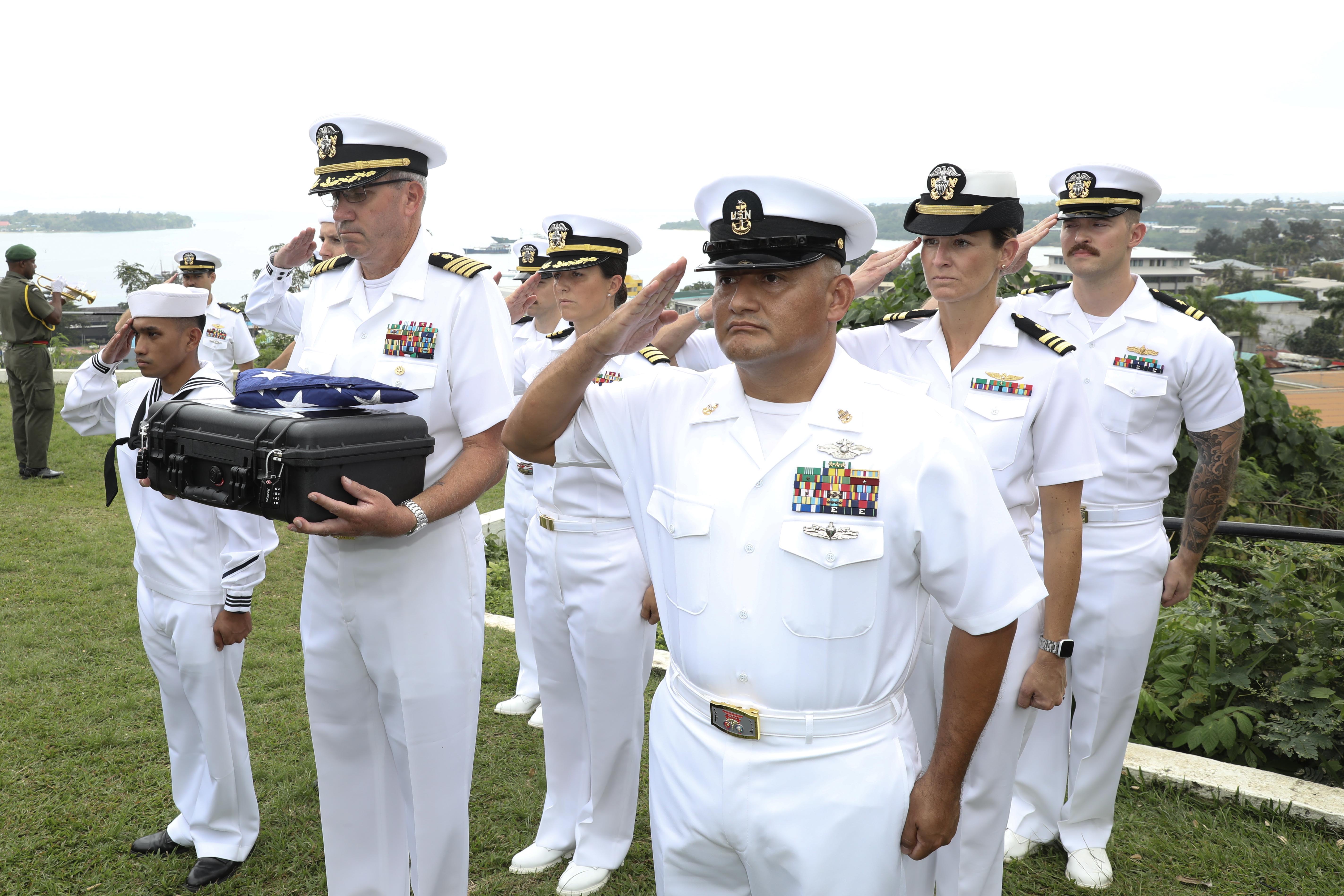 PORT VILA, Vanuatu (July 17, 2024) U.S. Navy Sailors assigned to Pacific Partnership 24-2 renders a salute while taps is played, during a ceremonial exchange attended by representatives from the Australian High Commission in Vanuatu, The U.S. State Department, the Vanuatu Mobile Force, the Defense POW/MIA Accounting Agency, Chairman of the Vanuatu National Cultural Council, USAID, and servicemembers assigned to Pacific Partnership 24-2 at the Efate Port Vila War Memorial in Port Vila, Vanuatu. July 17, 2024. The possible human remains evidence were recovered from a U.S. Navy PBY-5 Catalina that crashed in what is now the Republic of Vanuatu during World War II. The DPAA mission is to search for, find and account for missing Defense Department personnel from World War II, the Korean War, the Vietnam War, the Cold War, the Gulf War and other recent conflicts. More than 82,000 Americans remain missing from those conflicts, with 34,000 believed to be recoverable, according to DPAA. (U.S. Navy Photo by Mass Communication Specialist 1st Class Ryan D. McLearnon.)