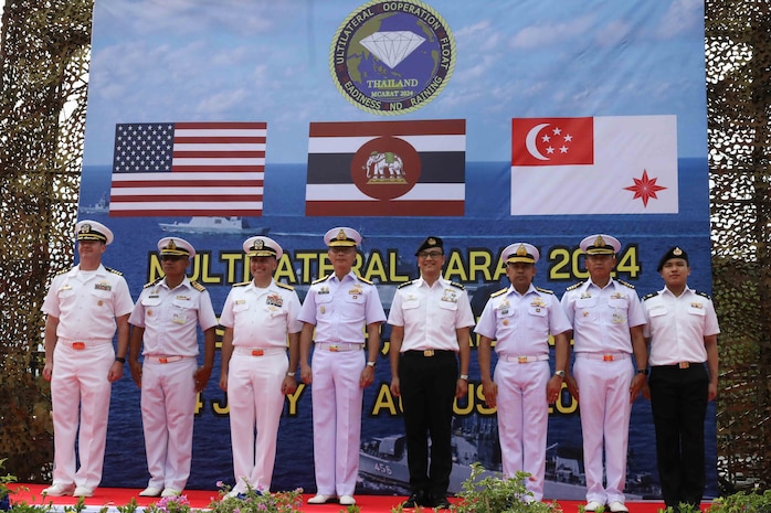 Members from the United States Navy, Royal Thai Navy, and Royal Singapore Navy stand at attention during the opening ceremony of Cooperation Afloat Readiness and Training (CARAT) Thailand 2024, Sattahip, Thailand, July 18, 2024.