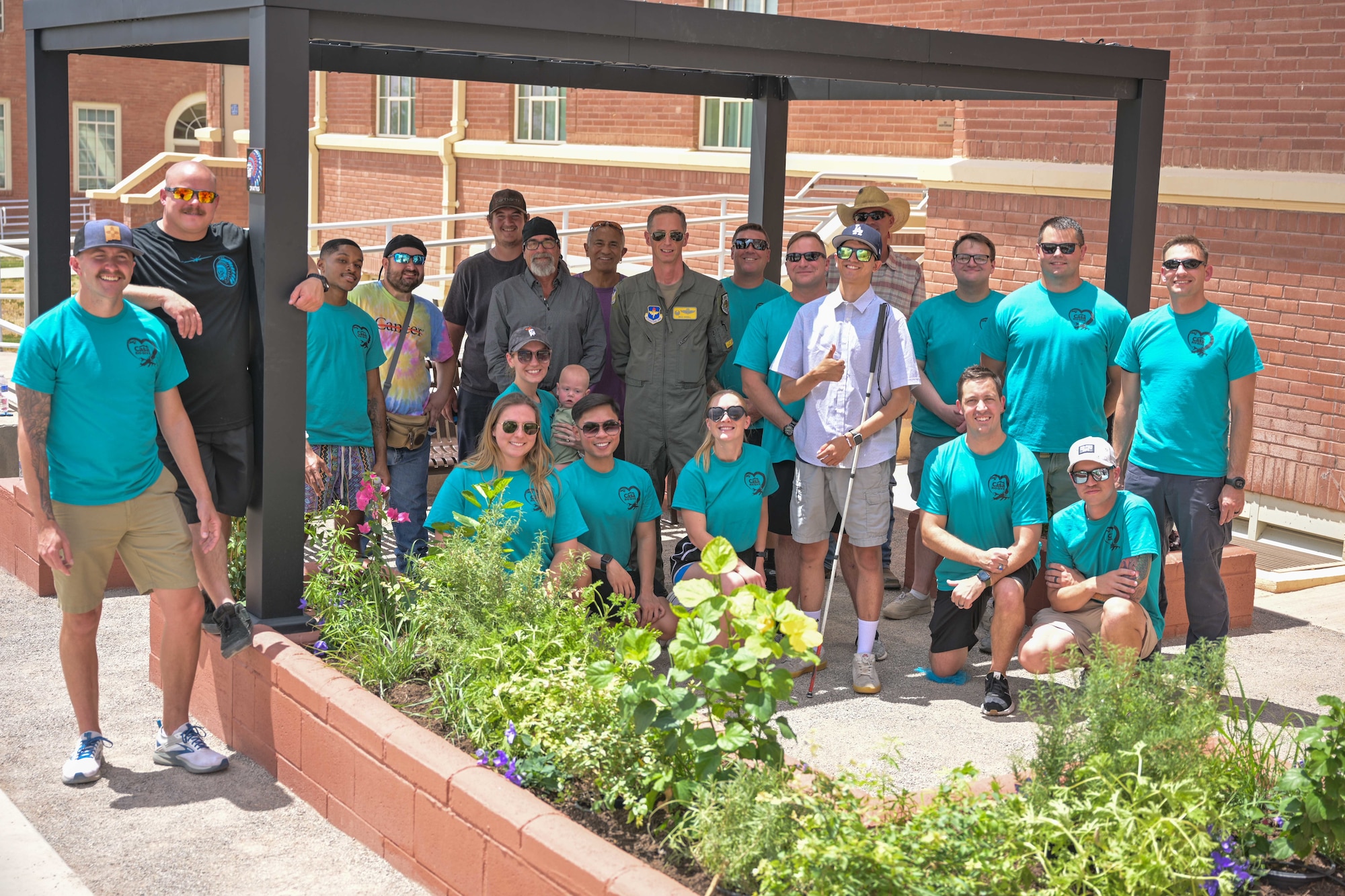 Members of the 29th Attack Squadron pose for a photo with staff and volunteers from the New Mexico School for the Blind and Visually Impaired after the opening of a garden in Alamogordo, New Mexico, July 19, 2024.