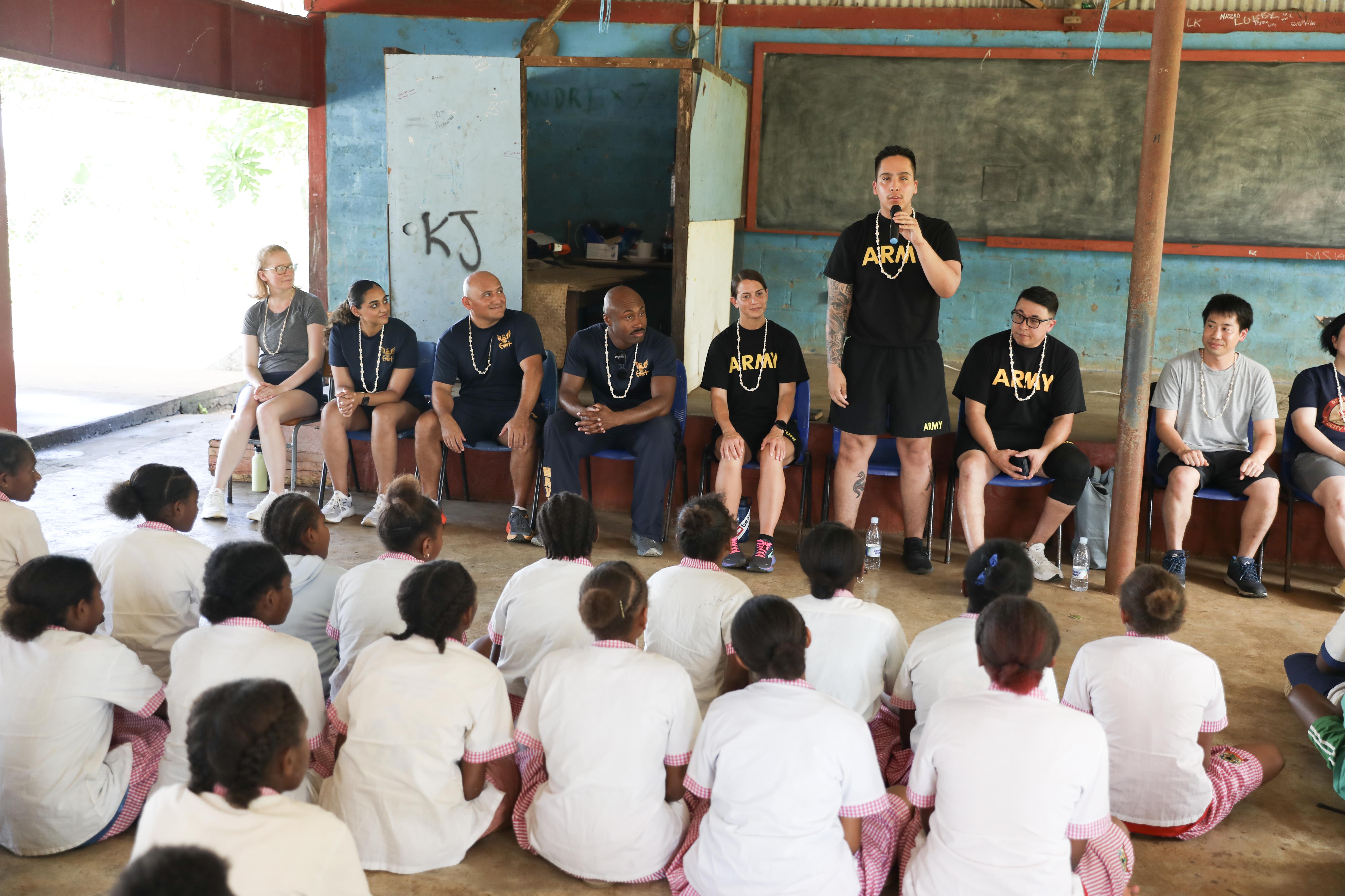 PORT VILA, Vanuatu (July 18, 2024) – U.S. Army Spc. Christopher Torres, standing, of Las Vegas, introduces himself to the students of Kawenu Primary School, during a community outreach event as part of Pacific Partnership 24-2 in Port Vila, Vanuatu, July 18, 2024. Pacific Partnership the U. S. Navy's largest humanitarian and civic assistance mission with partner-nations, non-governmental organizations and other government agencies to execute a variety of humanitarian civic action missions across the Indo-Pacific. The annual mission is designed to strengthen relationships and improve U.S. and partner-capacity to deliver humanitarian assistance and disaster-relief preparedness. (U.S. Navy photo by Mass Communication Specialist 1st Class Ryan D. McLearnon/Released)