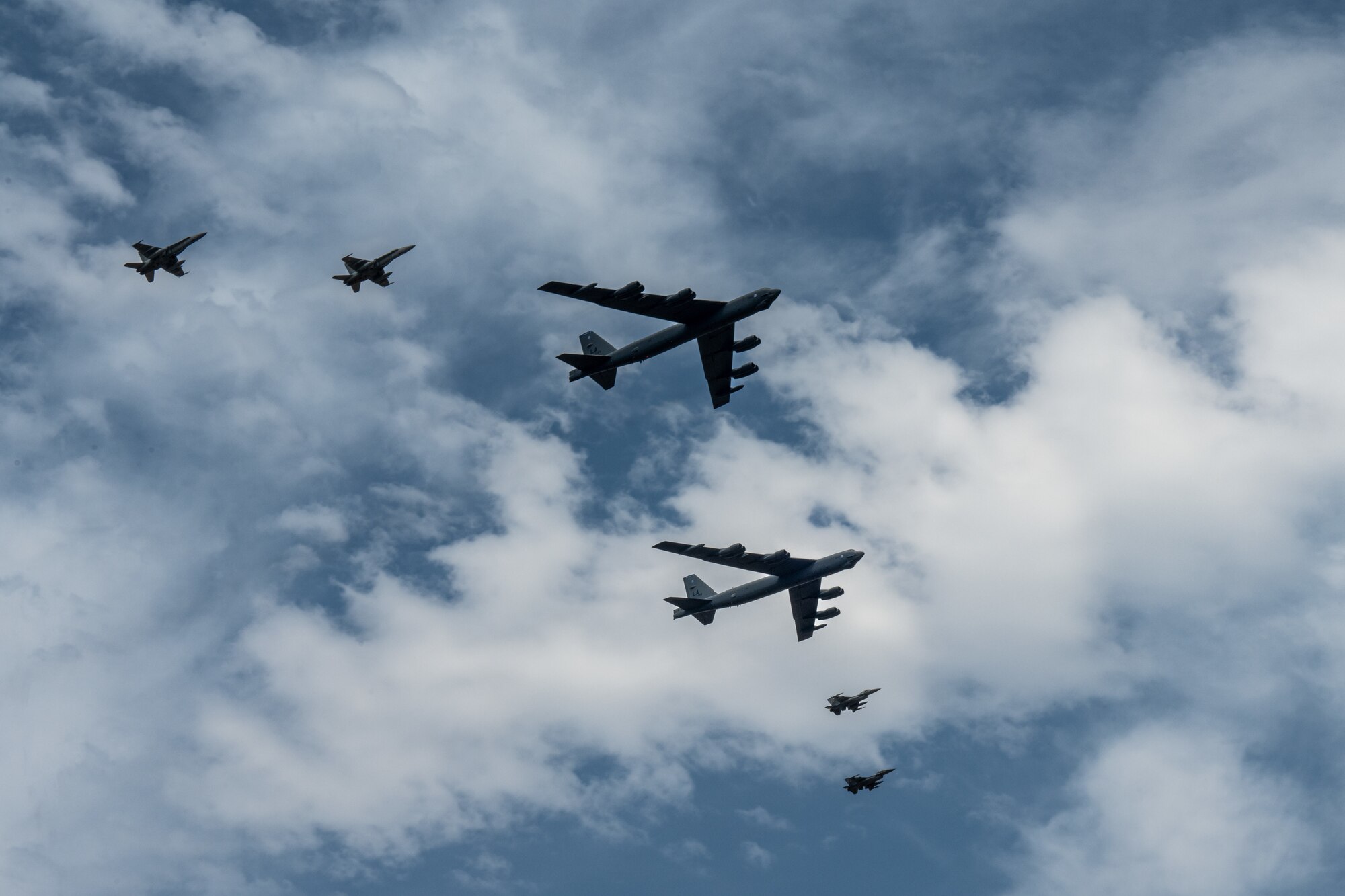 Two B-52H Stratofortresses from Barksdale Air Force Base, La., fly in formation with fighter jets from Romania and Finland as they arrive at Mihail Kogălniceanu Air Base, Romania, in support of Bomber Task Force Deployment 24-4, July 21, 2024. The U.S. Military works alongside NATO Allies and partners to ensure a safe, stable, and secure Euro-Atlantic region by increasing military capabilities, readiness, and interoperability. (U.S. Air Force Photo by Senior Airman Seth Watson)