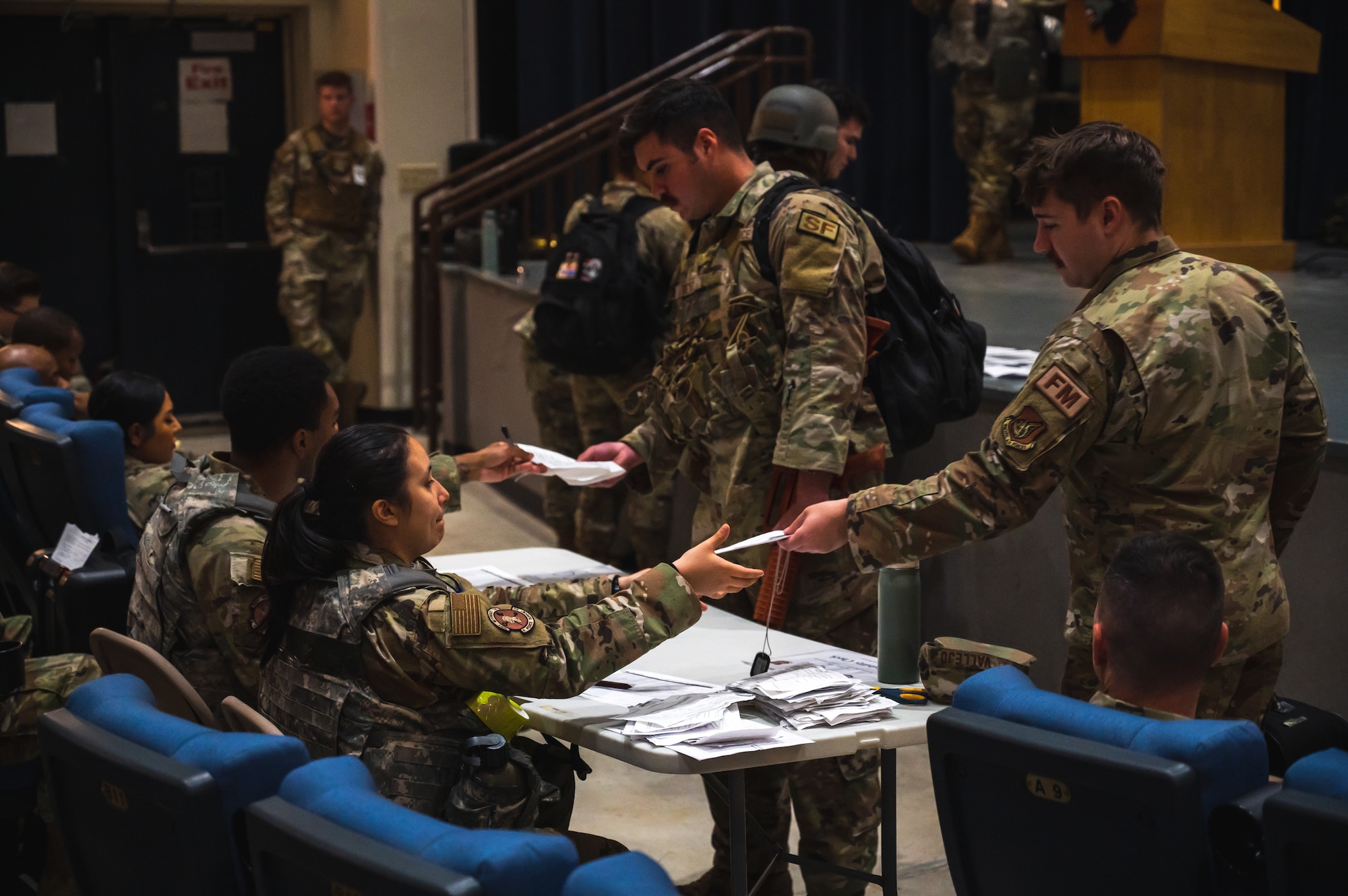 Senior Airman Tate Kinney, 8th Comptroller Squadron financial analysis technician, turns in in-processing paperwork at the base theater during exercise Beverly Sentinel 24-2 at Kunsan Air Base.