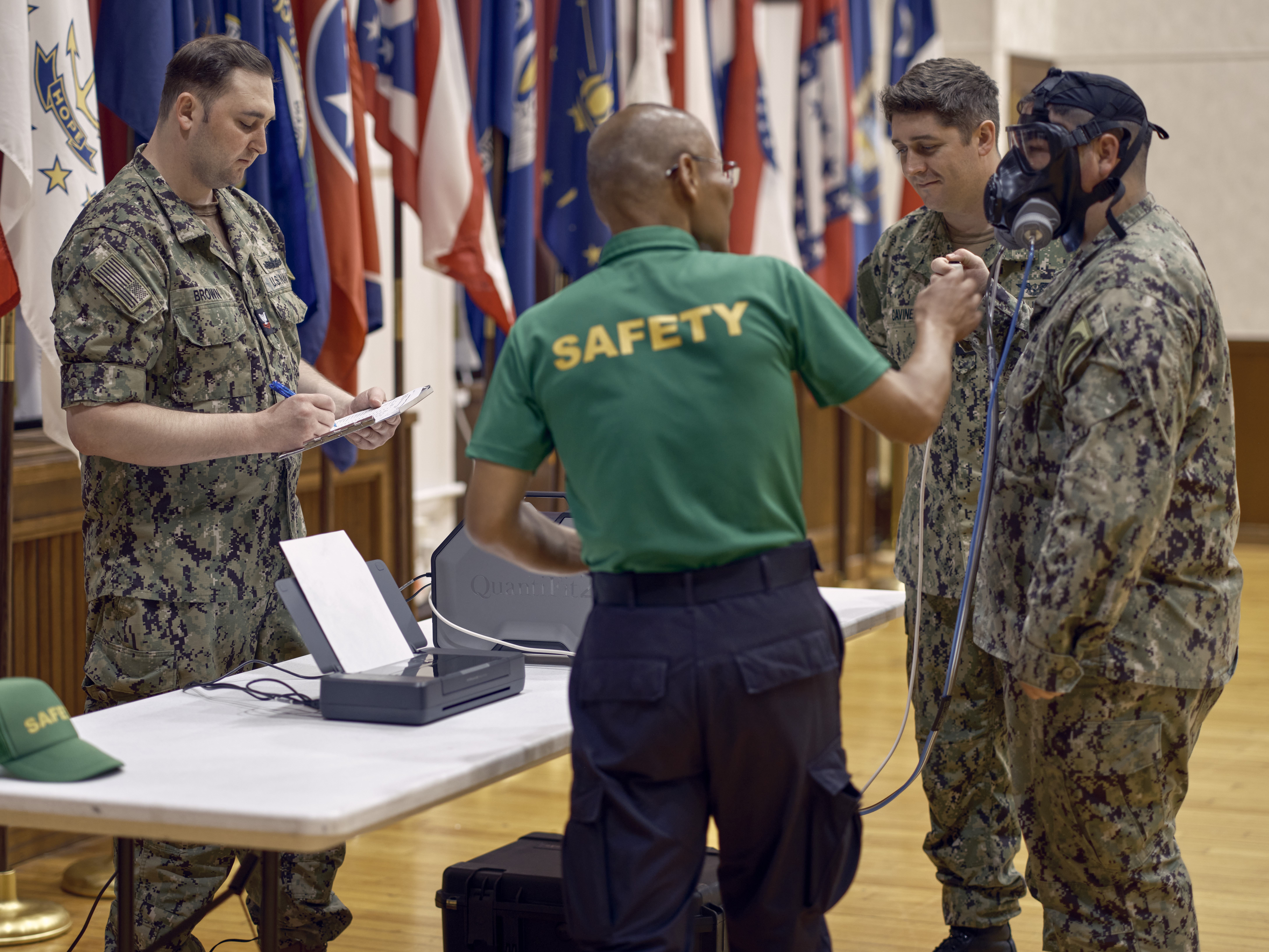 Aviation Boatswain's Mate Handling 1st Class Dominic Caviness and Damage Controlman 2nd Class Marcus Brown, both of Commander, Fleet Activities Yokosuka (CFAY) Emergency Management Department, fit Damage Controlman 2nd Class Tyler Burkhart of CFAY Emergency Operations Center for an M-50 Chemical, Biological, Radiological (CBR) defense mask with Jun Iwaki of CFAY Safety Department, the installation's Fit Test Lead, supervising July 18, 2024 in the C-2 Auditorium as part of Exercise Citadel Pacific 2024.