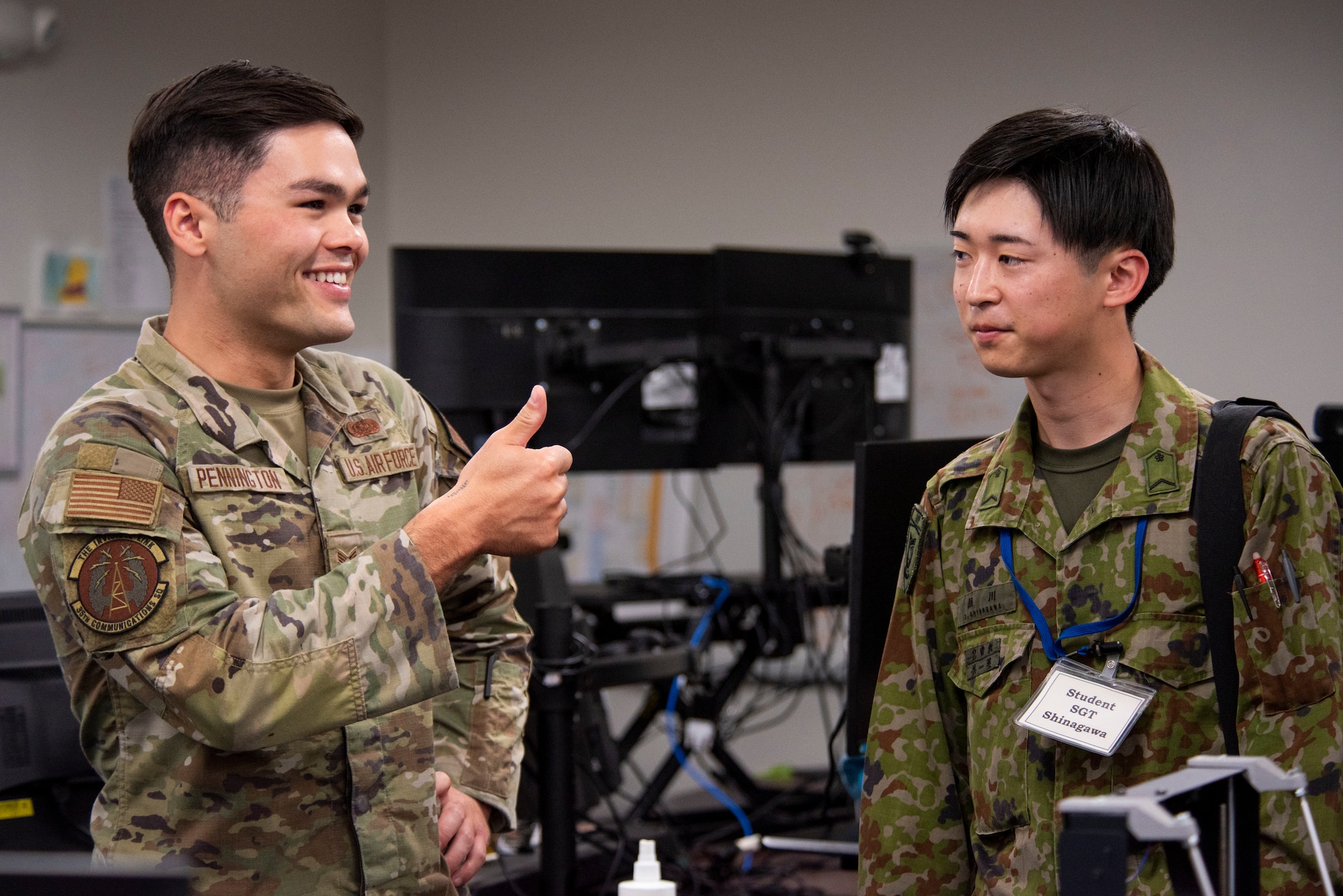 U.S. Air Force Senior Airman Tanner Pennington, left, 35th Communications Squadron cyber transport technician, gives a thumbs up to Japan Ground Self-Defense Force Sgt. Daimu Shinagawa, Basic English Training course student, during a JGSDF Basic English Training Course tour at Misawa Air Base, Japan, July 18, 2024.