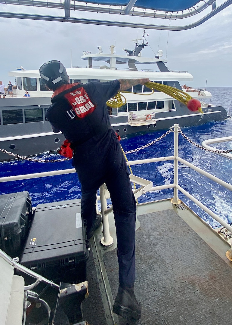 A crewman aboard USCGC Oliver Henry (WPC 1140) tosses a heaving line to set up a tow to the crew of the 150-foot 497-ton motor yacht Black Pearl 1, located approximately 200 nautical miles west of the Republic of Palau on July 21, 2024, after responding to a distress call. The 11-person yacht crew, who reported a locked rudder and flooding in the bilge, was assisted by Oliver Henry's crew with dewatering and damage control as they headed toward Palau in 25 mph winds and 4 to 6-foot seas. (U.S. Coast Guard photo by Ensign Mikasa Lierman)