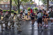 U.S. Soldiers dance with a crowd during Via Gladiola at the Nijmegen March on July 19, 2024, in Nijmegen, Netherlands. Via Gladiola was a parade for finishers of the march that take place throughout the city of Nijmegen.
