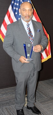 Jessie James Lee, a cybersecurity manager and competency supervisor for the Naval Information Warfare Center Atlantic New Orleans (NOLA) detachment, poses with his Excellence in Service Award from the New Orleans Federal Executive Board (FEB) following an award ceremony June 13 at the U.S. Department of the Interior Bureau of Safety and Environmental Enforcement New Orleans Office. Lee won at the local level in the Senior Manager/Director category and at the national level, winning the National Office of Personnel Management (OPM) Outstanding Leadership Award.